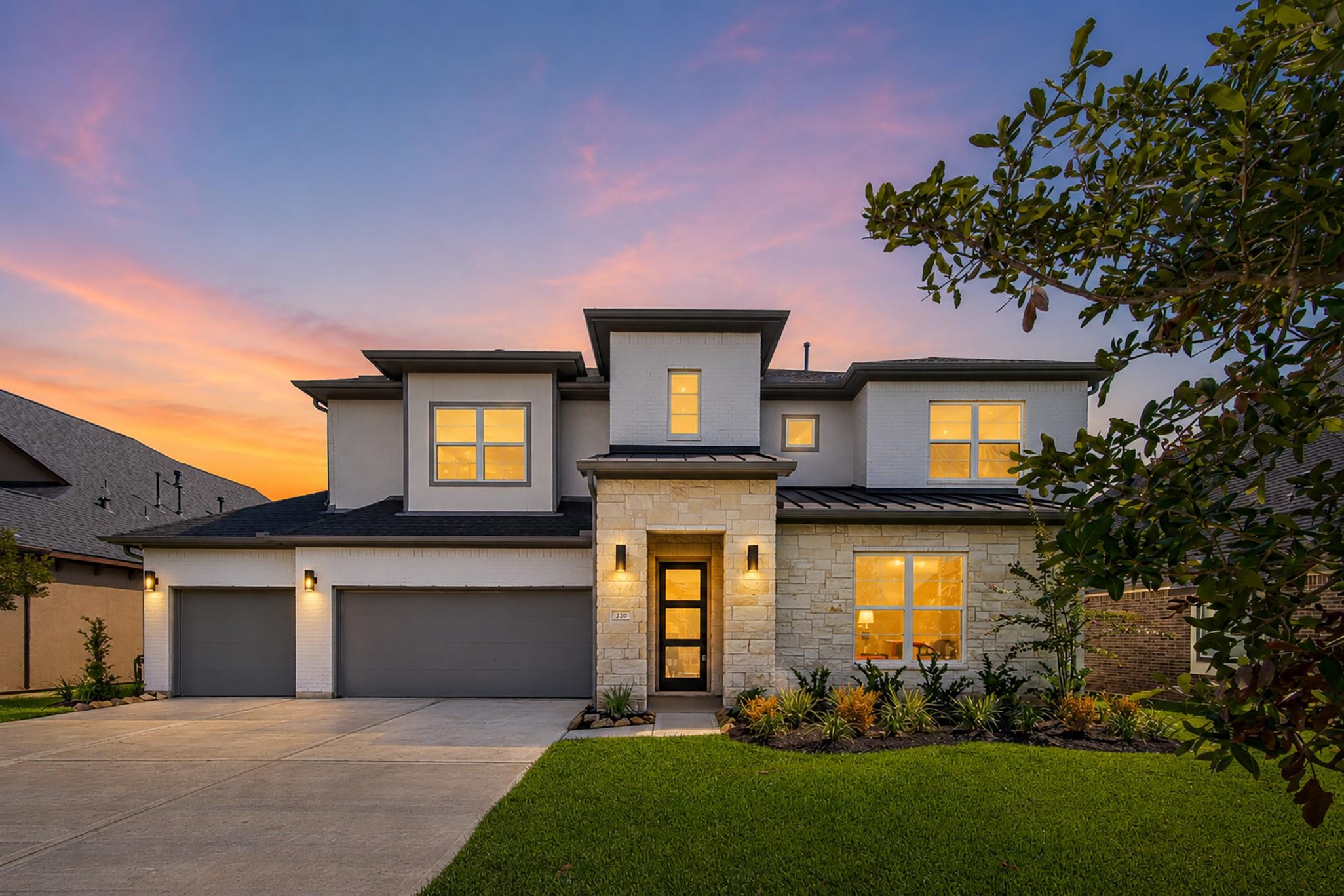 Image 1: Twilight view of the home&rsquo;s modern exterior, welco