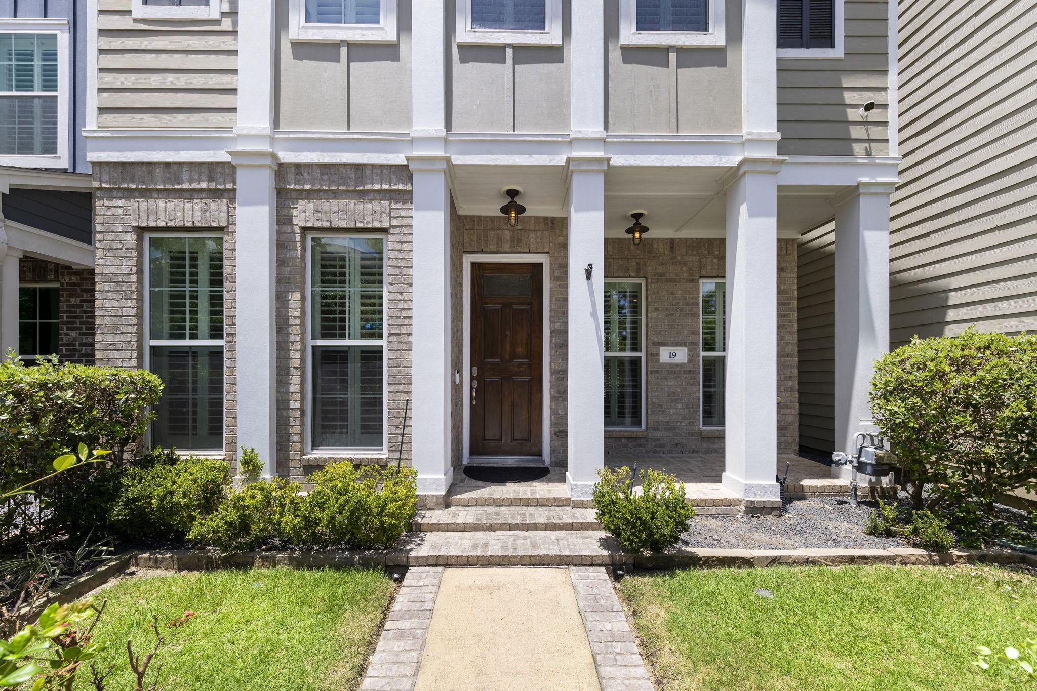 Image 2: A charming covered front porch framed by stately c