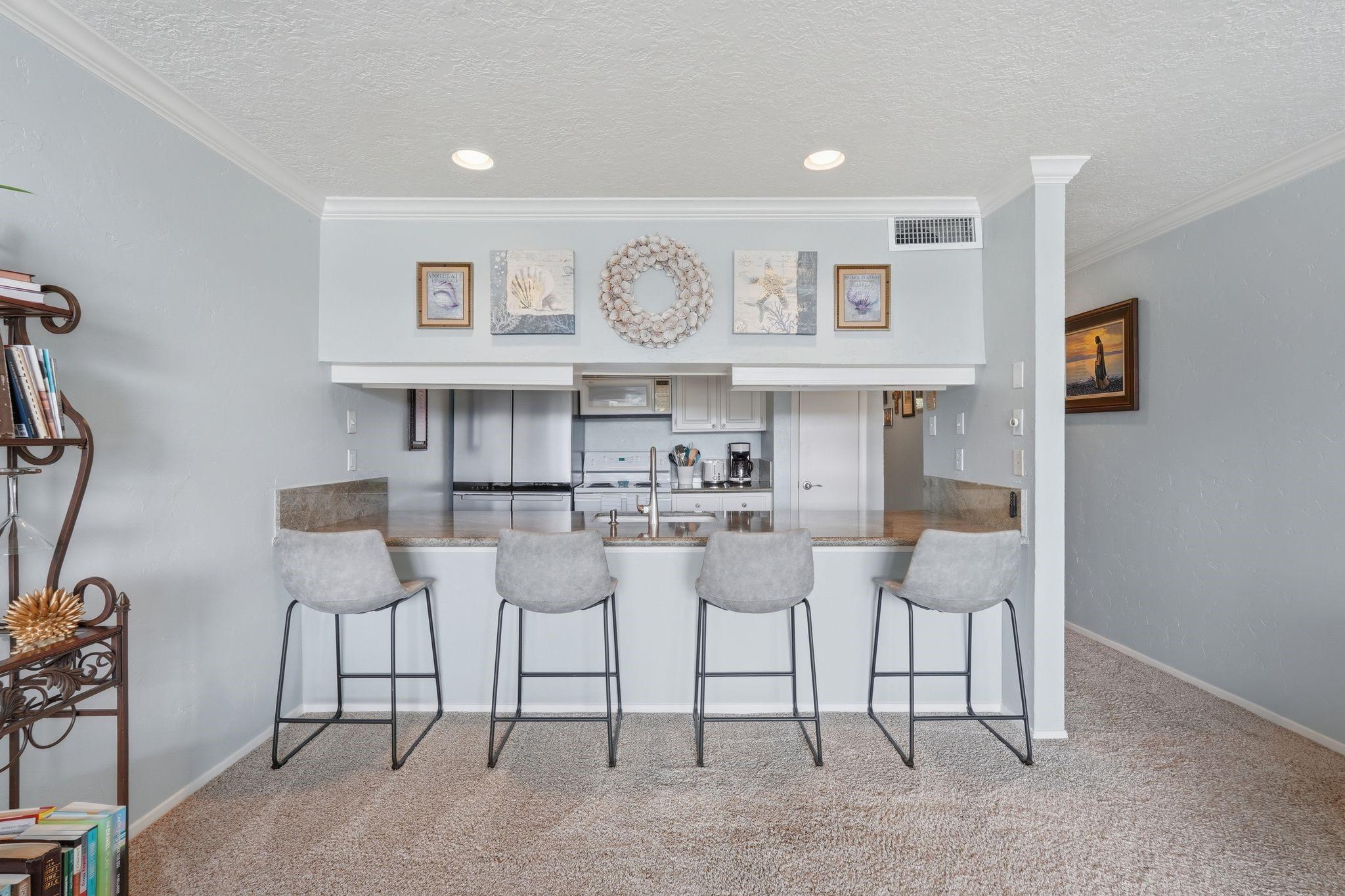 Image 3: Kitchen with white cabinets and bar seating