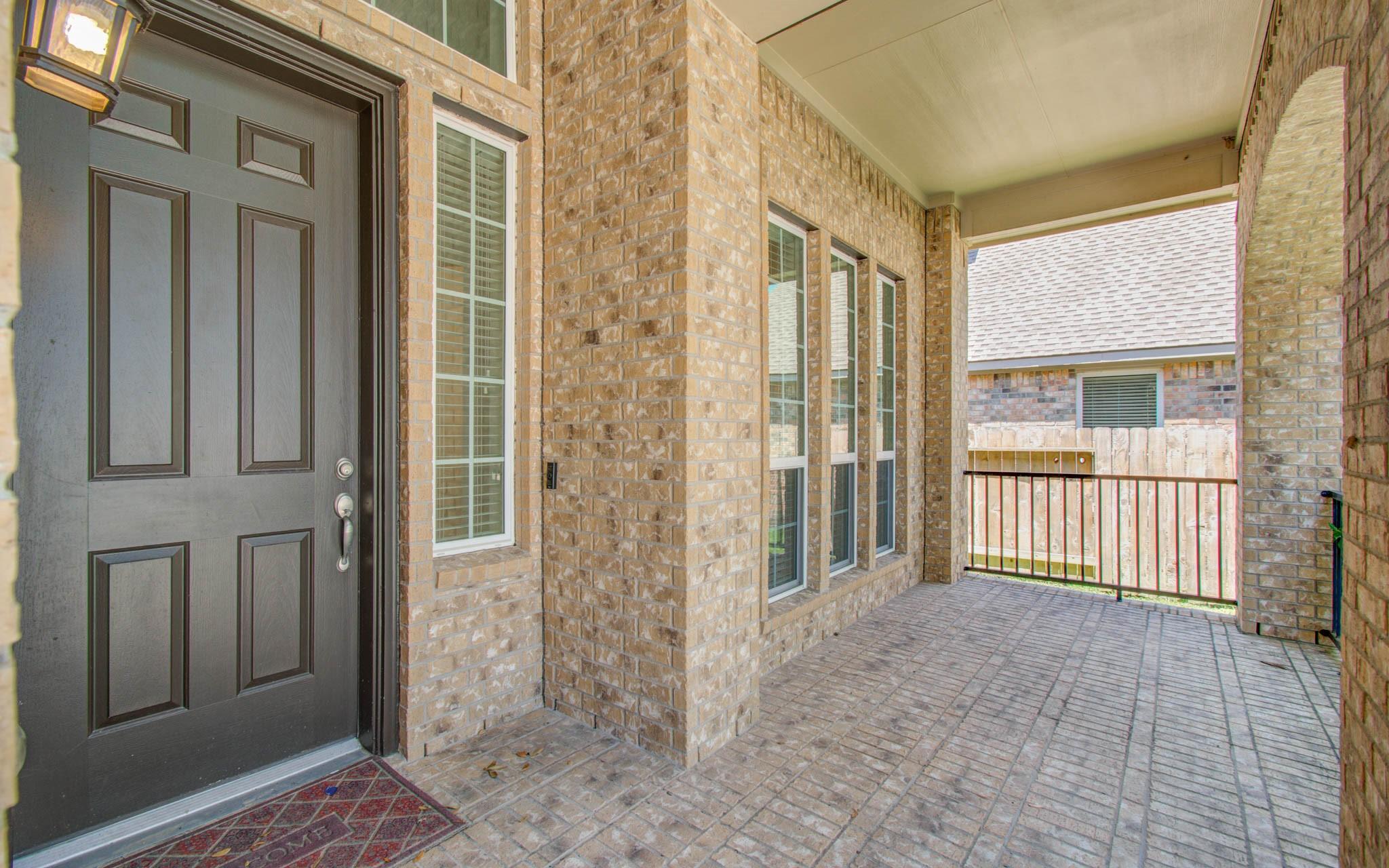 Image 4: Charming covered entryway with brick walls and lar