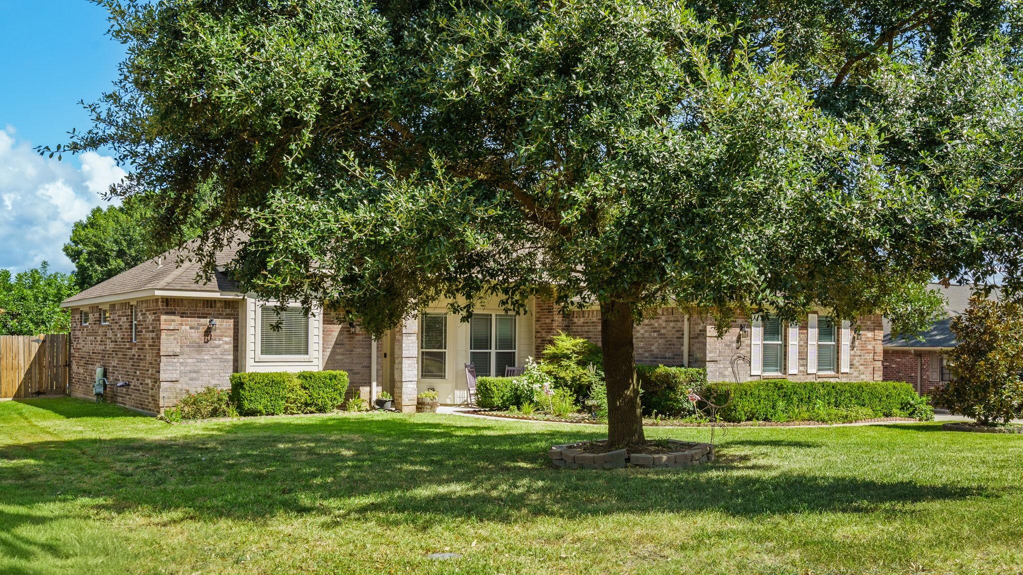 Image 2: Charming brick facade enhanced by lush greenery an