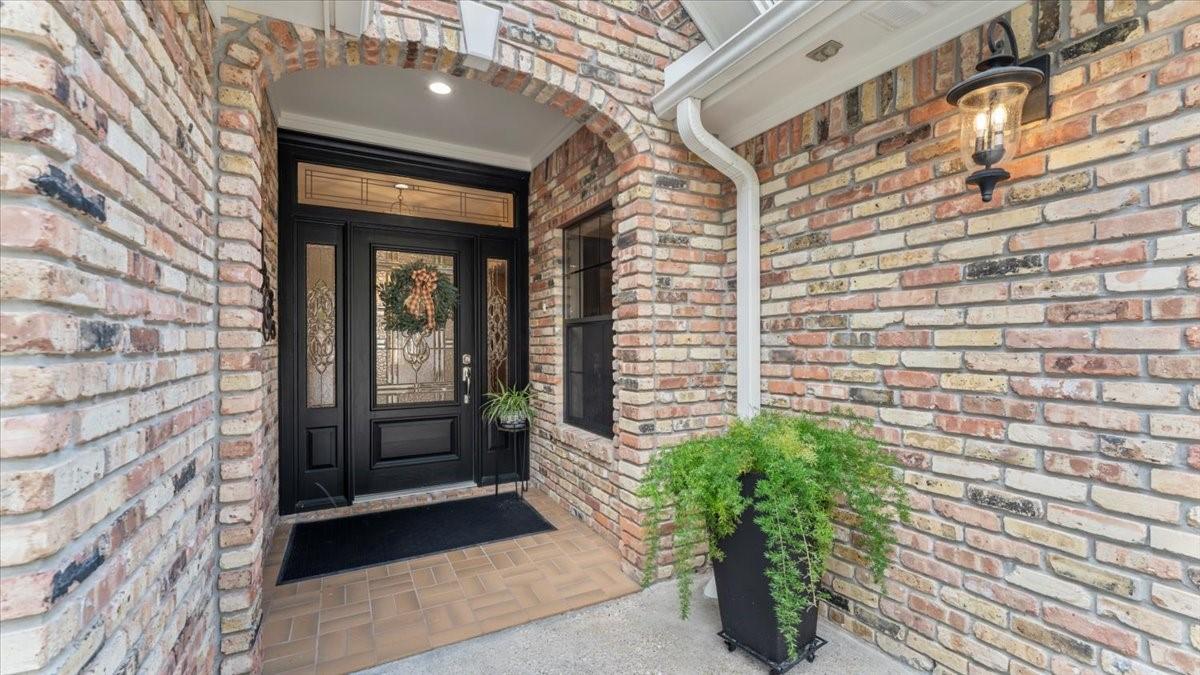 Image 2: This inviting entryway features a charming brick e