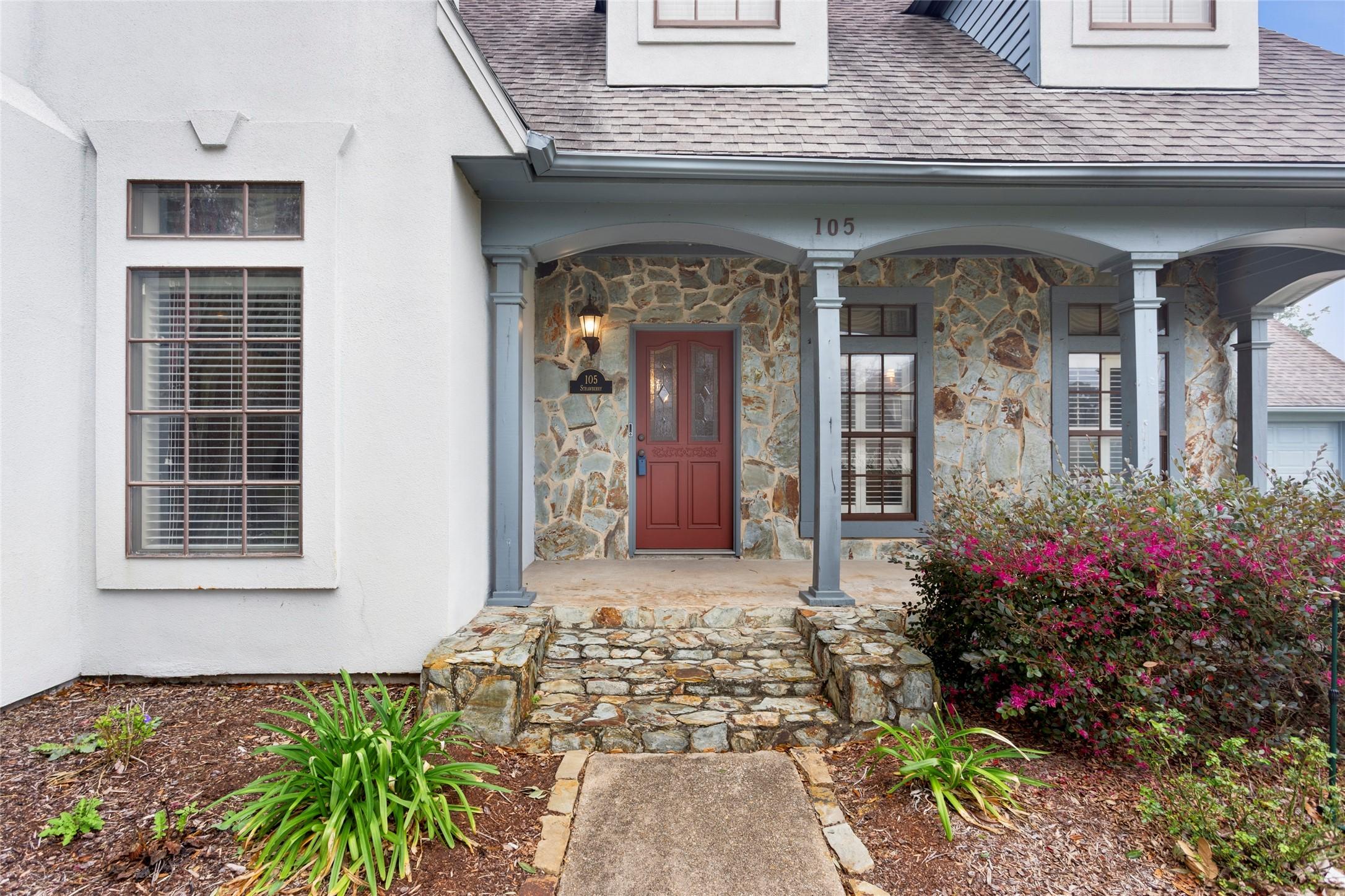 Image 2: A welcoming front elevation with stone accents, wa