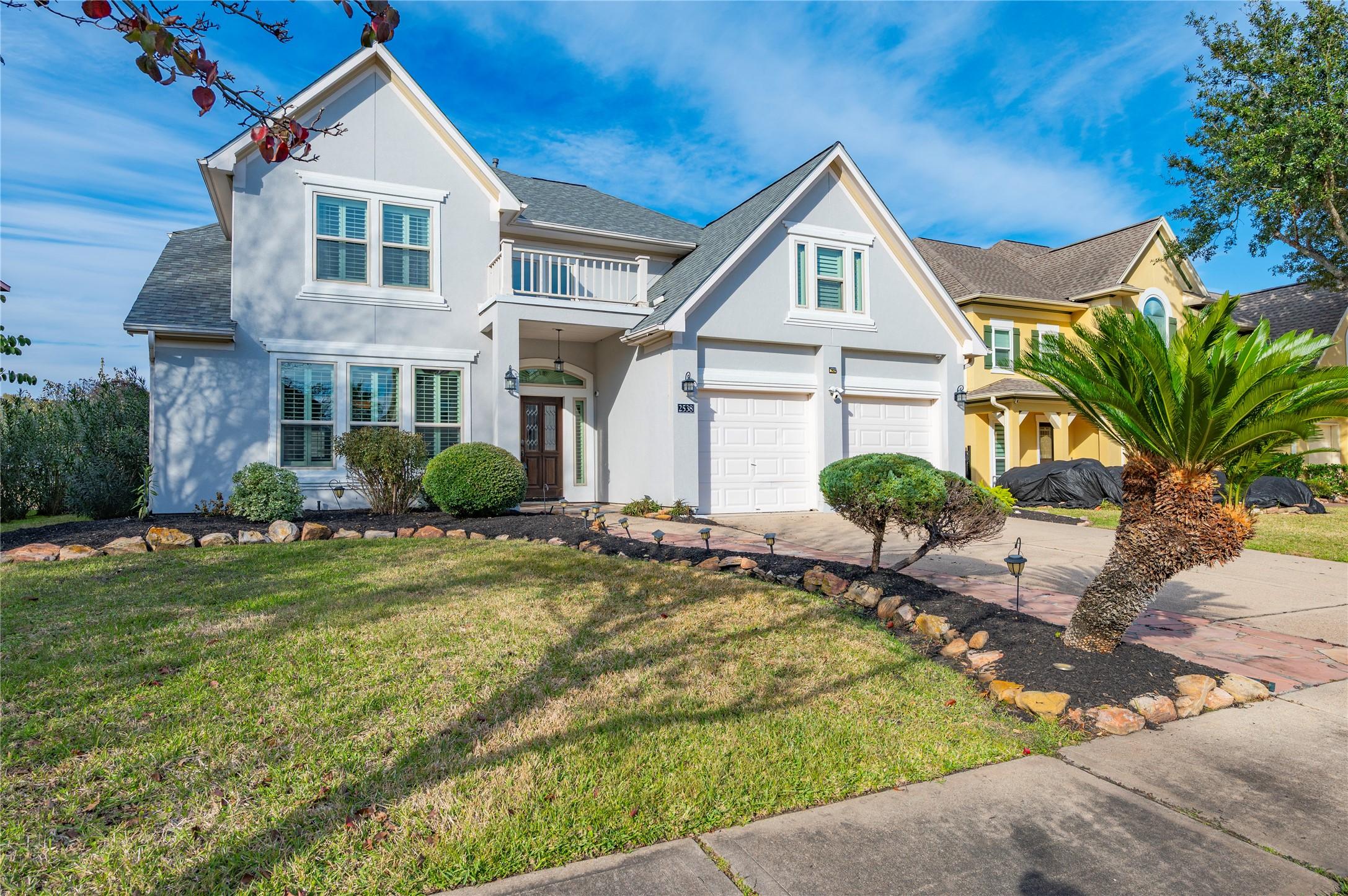 Image 4: This home features a well-maintained front yard wi