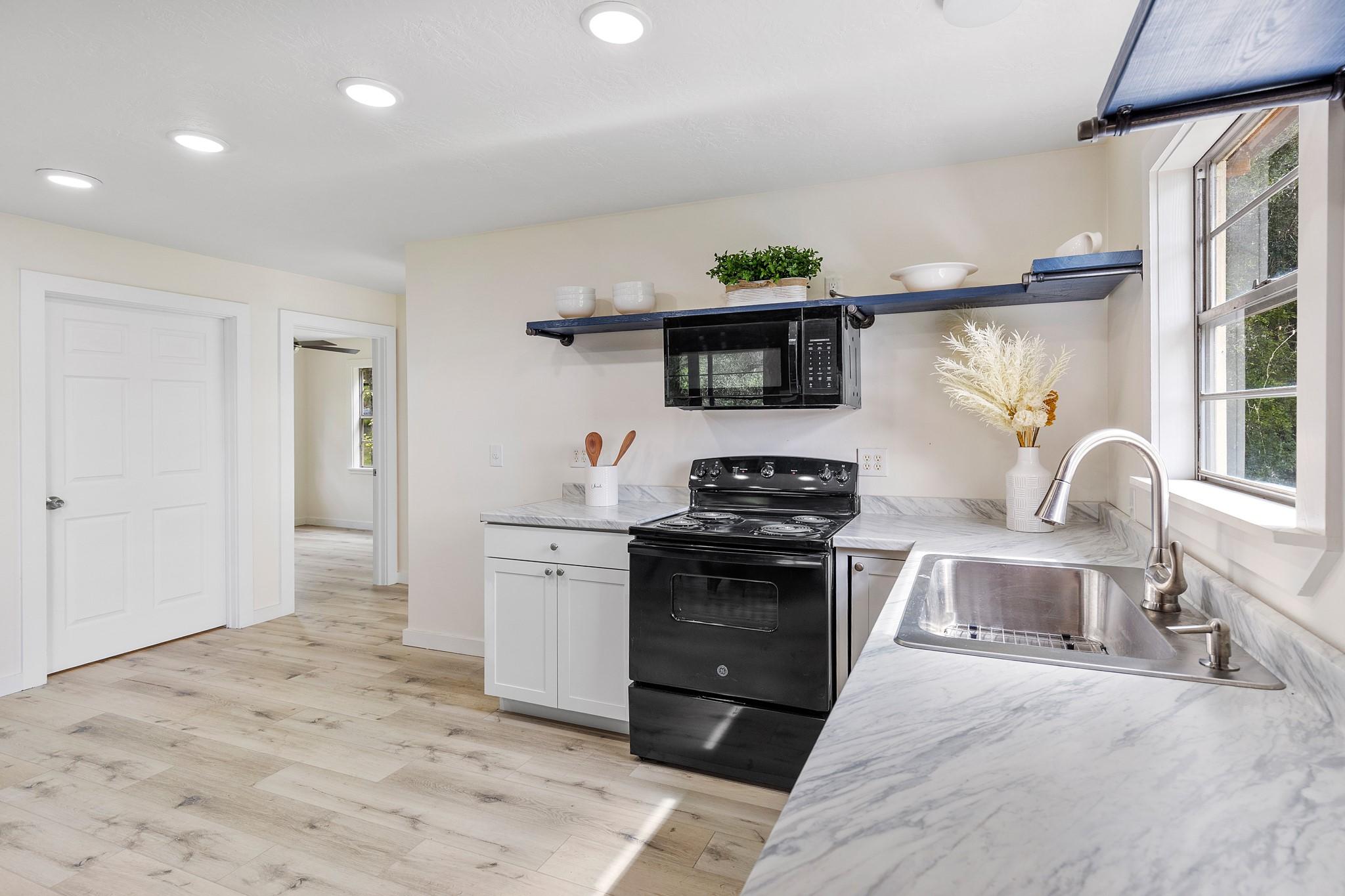 Image 2: Farmhouse sink and beautiful floors.