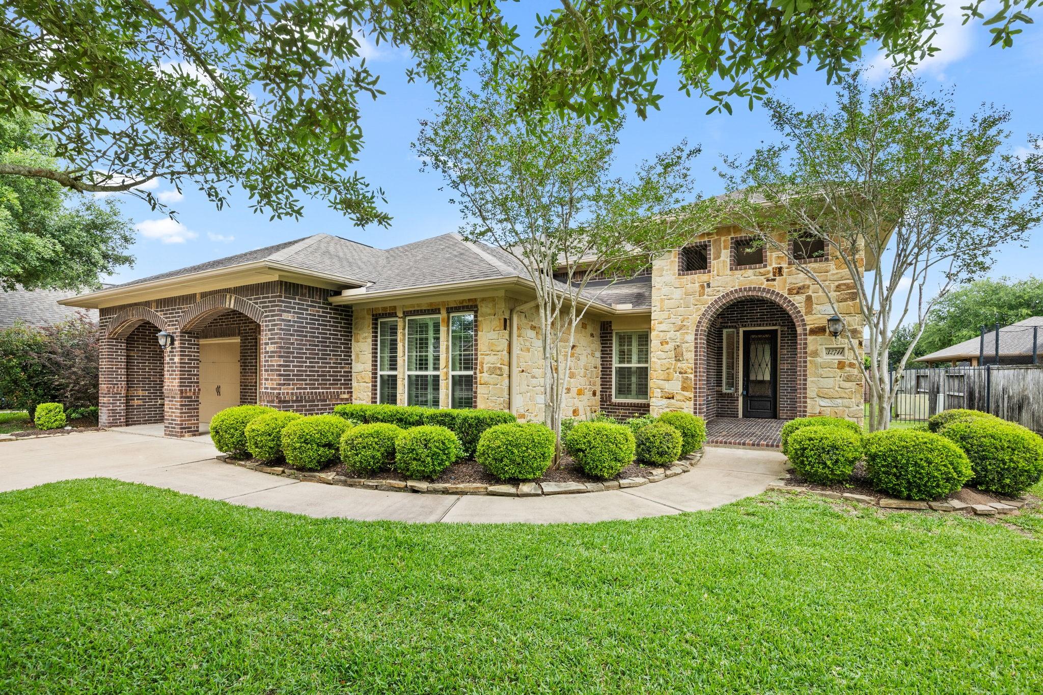 Image 1: Charming single-story home with a mix of stone and