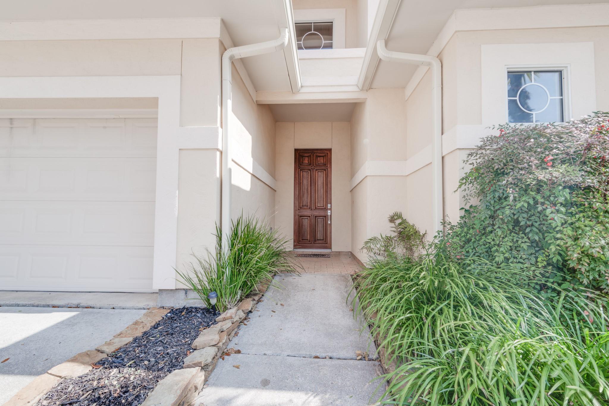 Image 3: Covered entryway and two car garage.