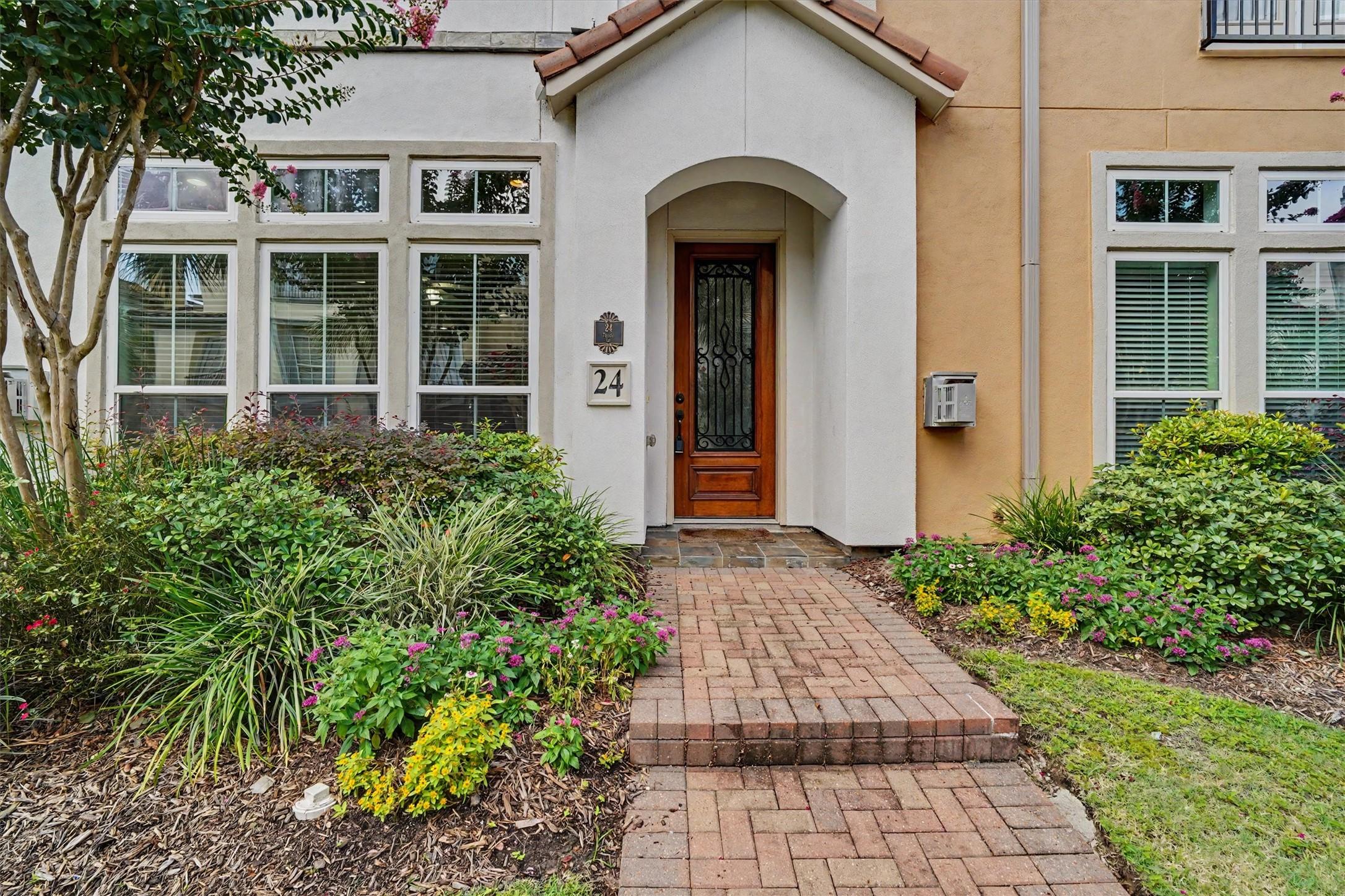 Image 2: Charming entrance with a beautifully landscaped pa
