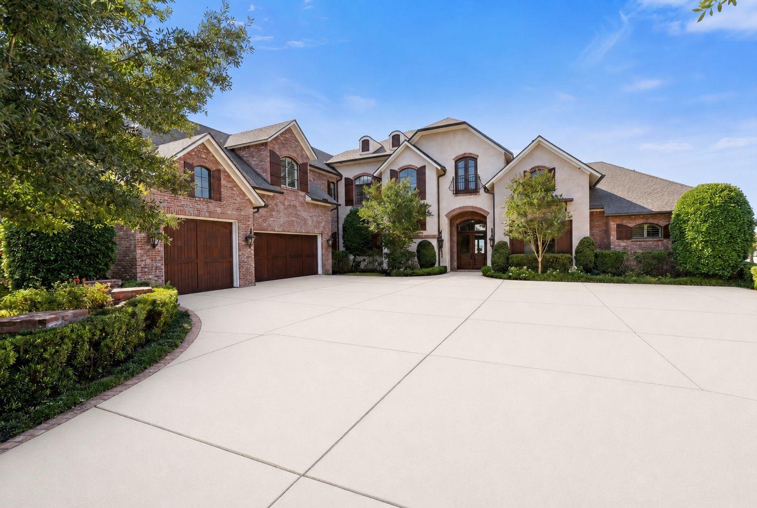 Image 4: Grand brick-and-stucco facade, three-car garage, a