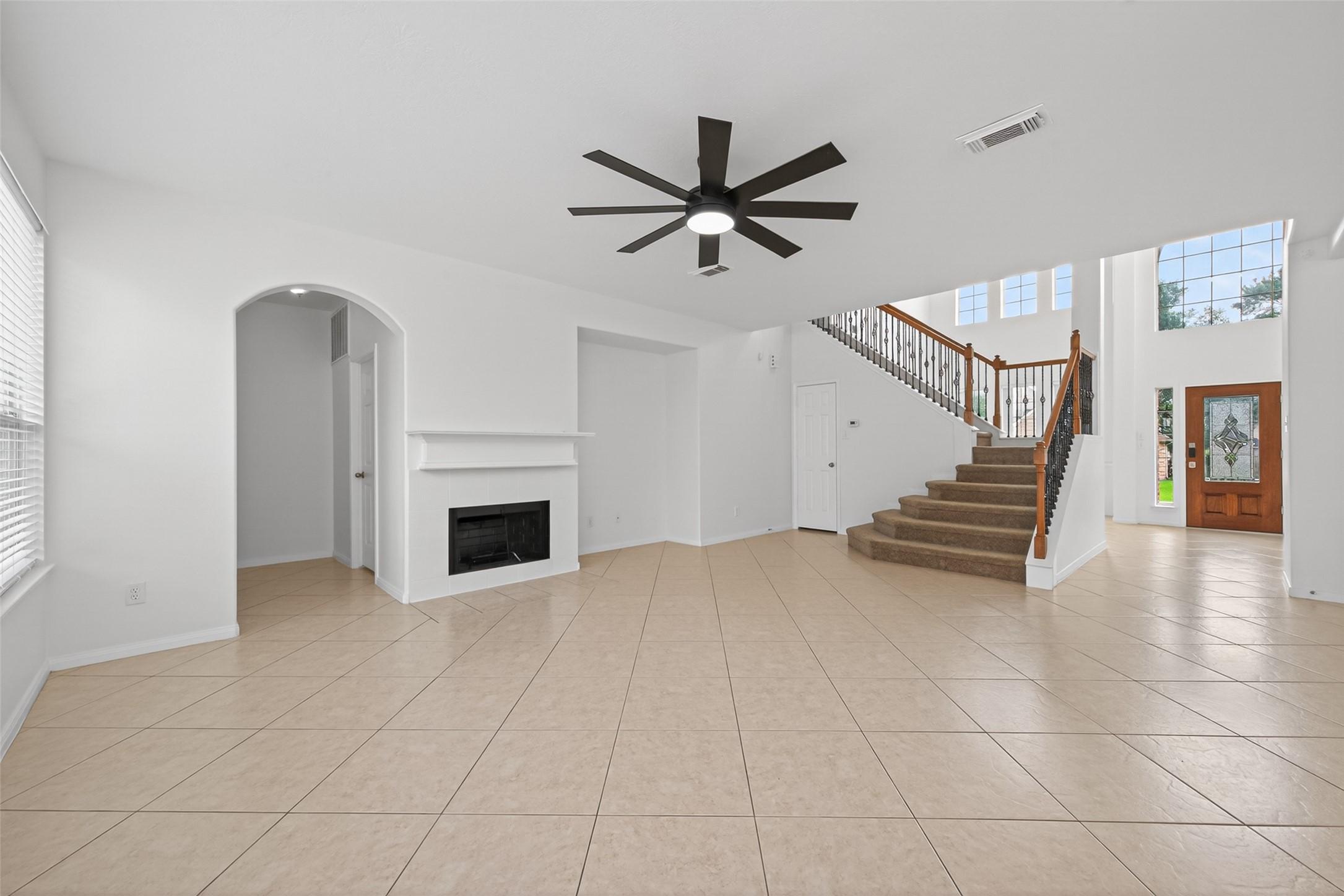 Image 2: Spacious living area with elegant tile flooring, a