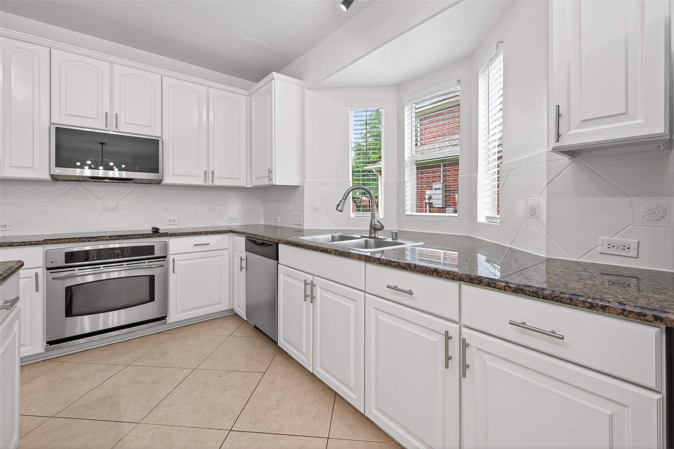 Image 3: Bright kitchen with sleek stainless steel applianc