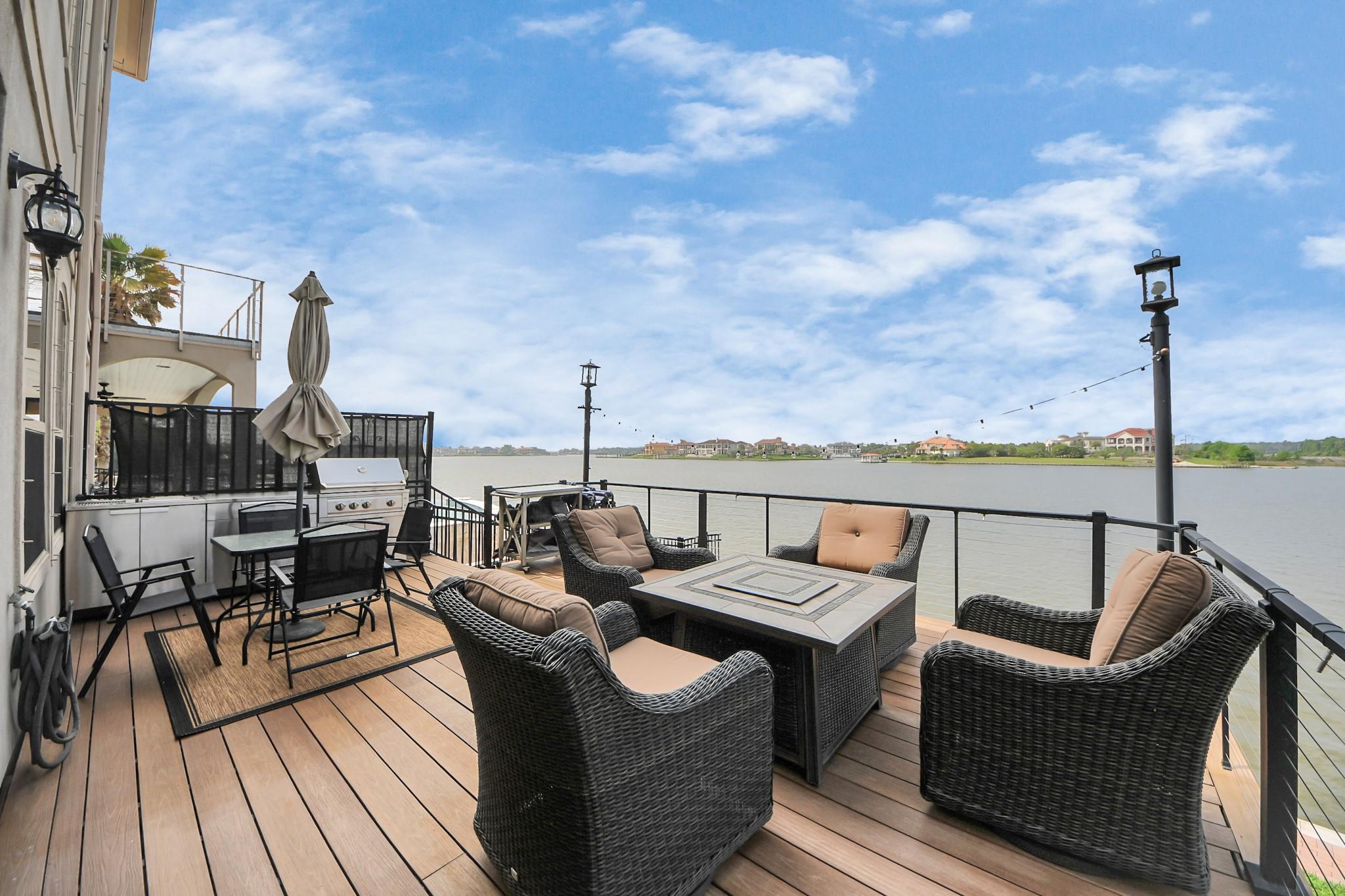 Image 1: This photo showcases a spacious waterfront deck wi