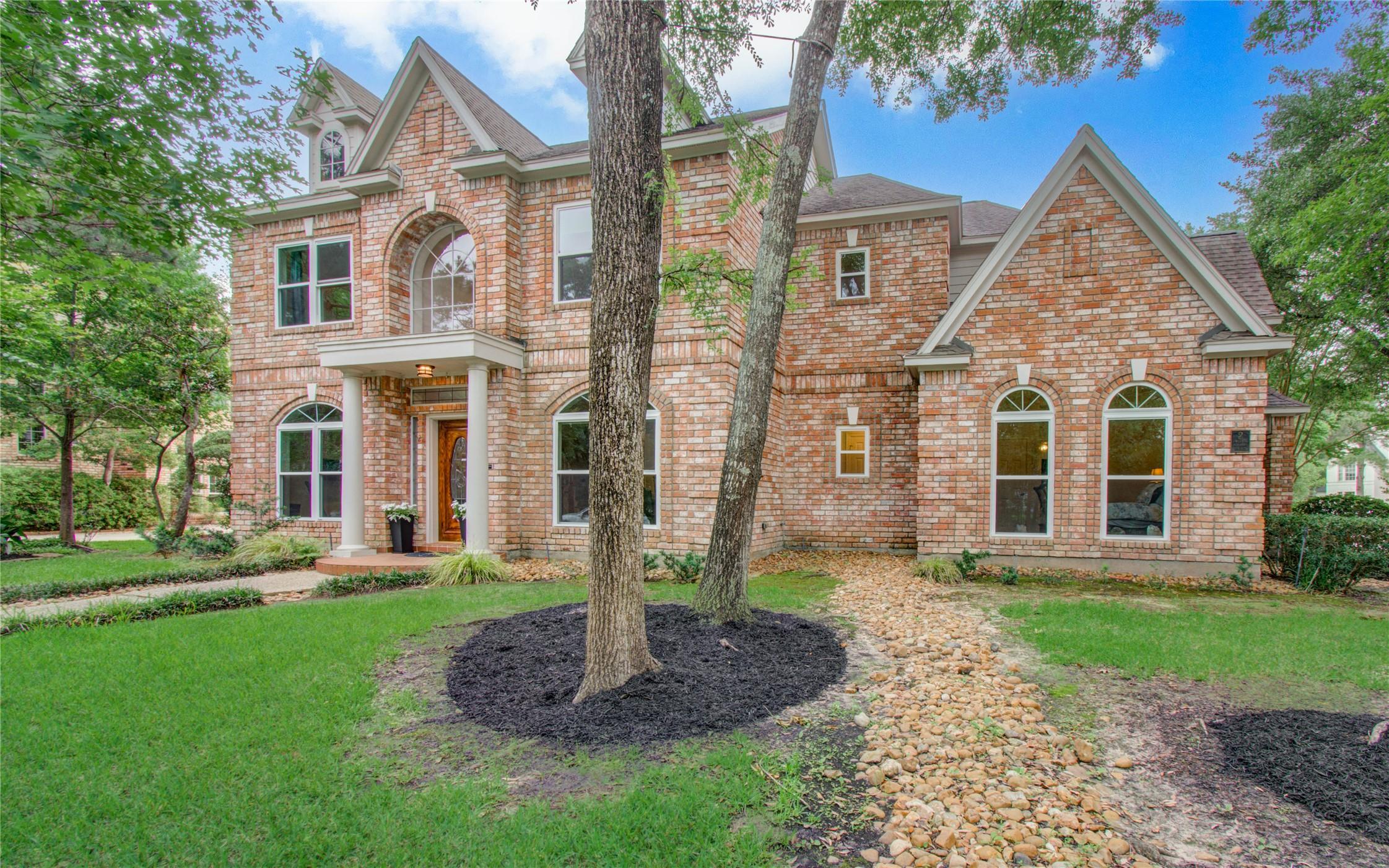 Image 2: This photo showcases a charming two-story brick ho