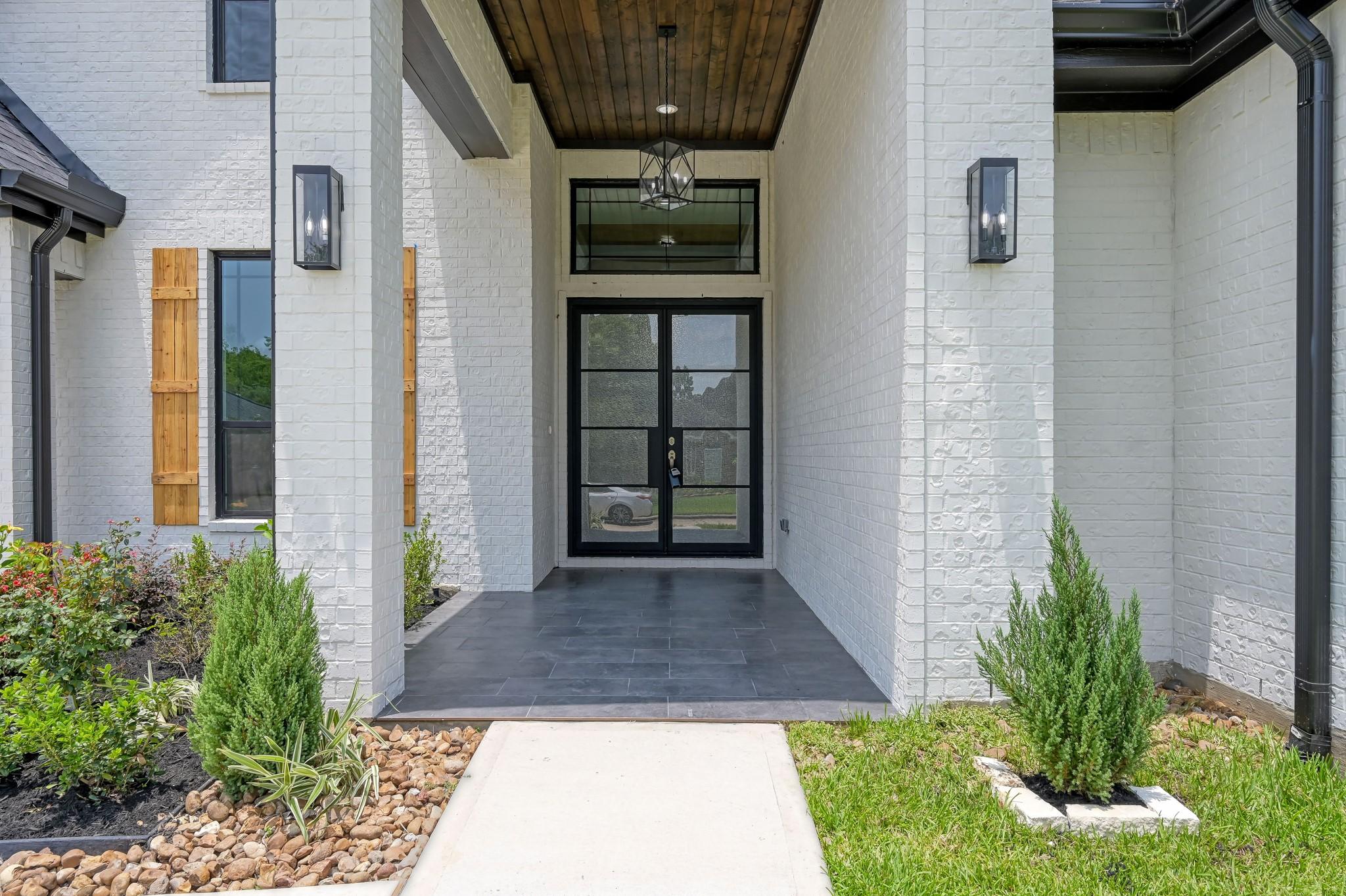 Image 2: Double iron and glass front doors set the tone for