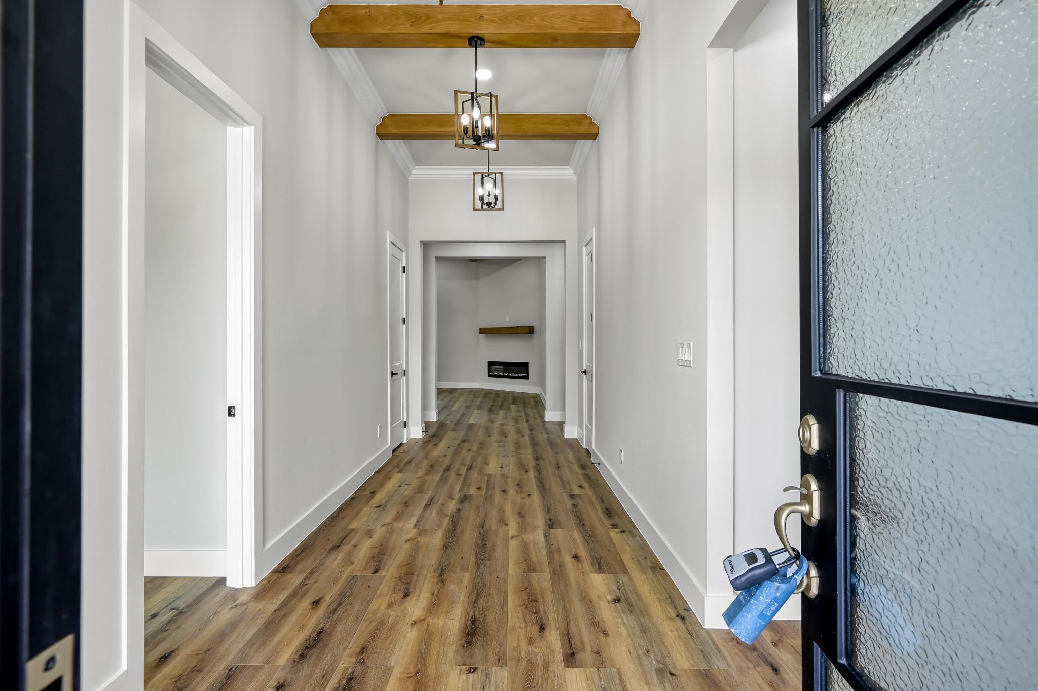 Image 3: The grand entry showcases 12&rsquo; ceilings, wood beams