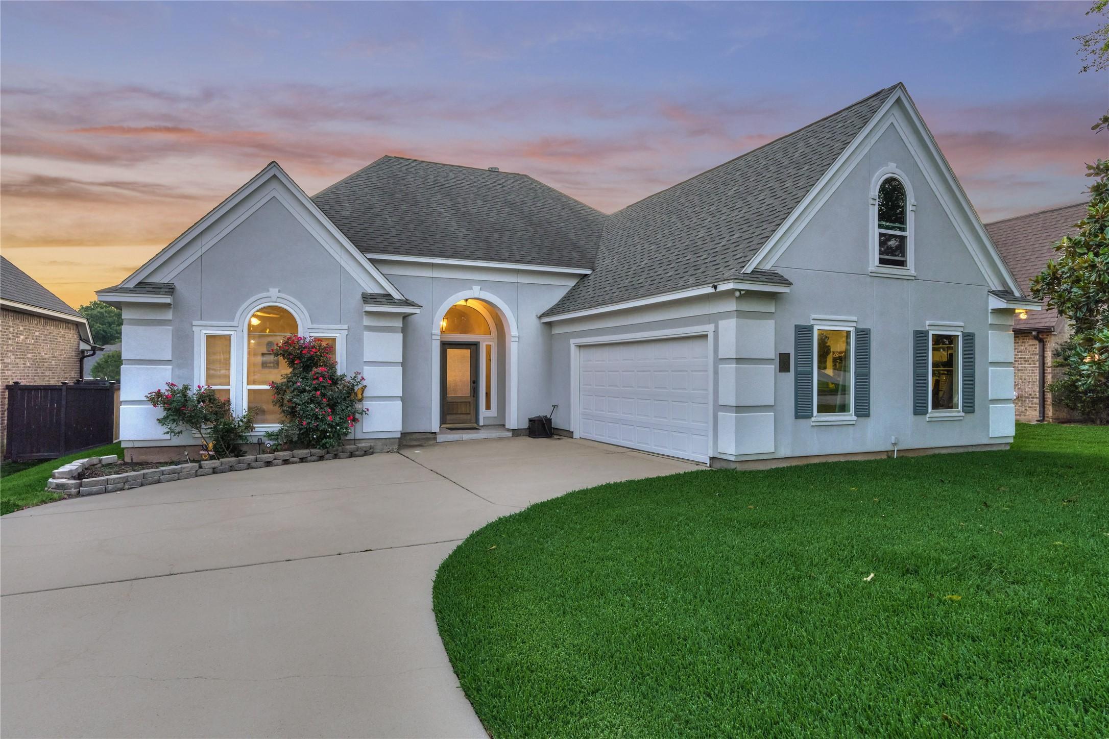 Image 4: Elegant stucco exterior with a two-car garage and