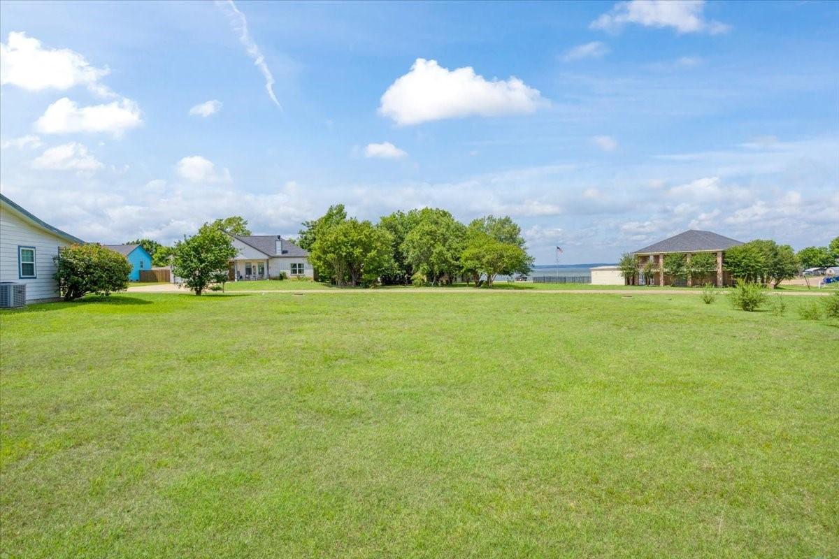 Image 4: Open grassy homesite located near community pavili