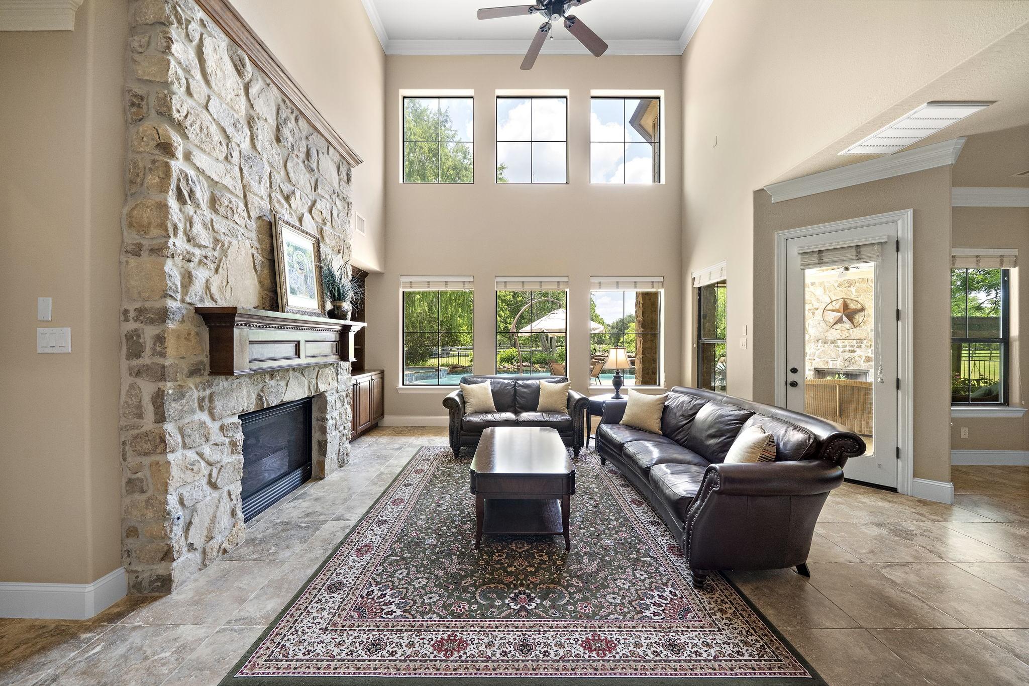 Image 3: This spacious living room features a stunning ston