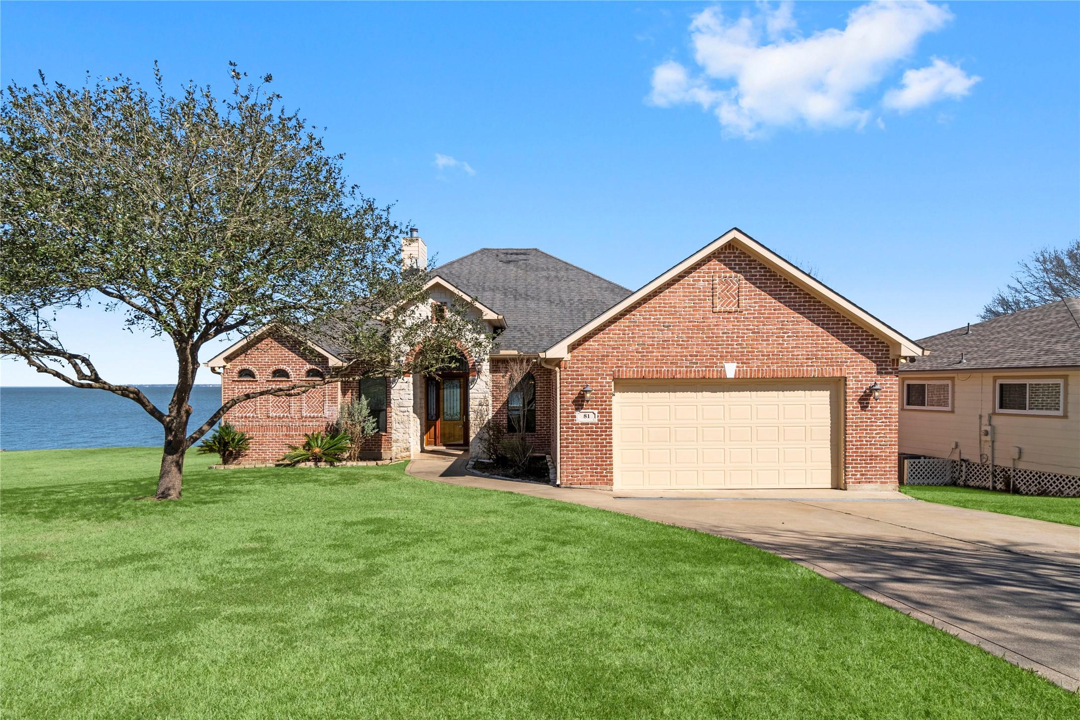 Image 1: a charming brick home with a large front yard, de
