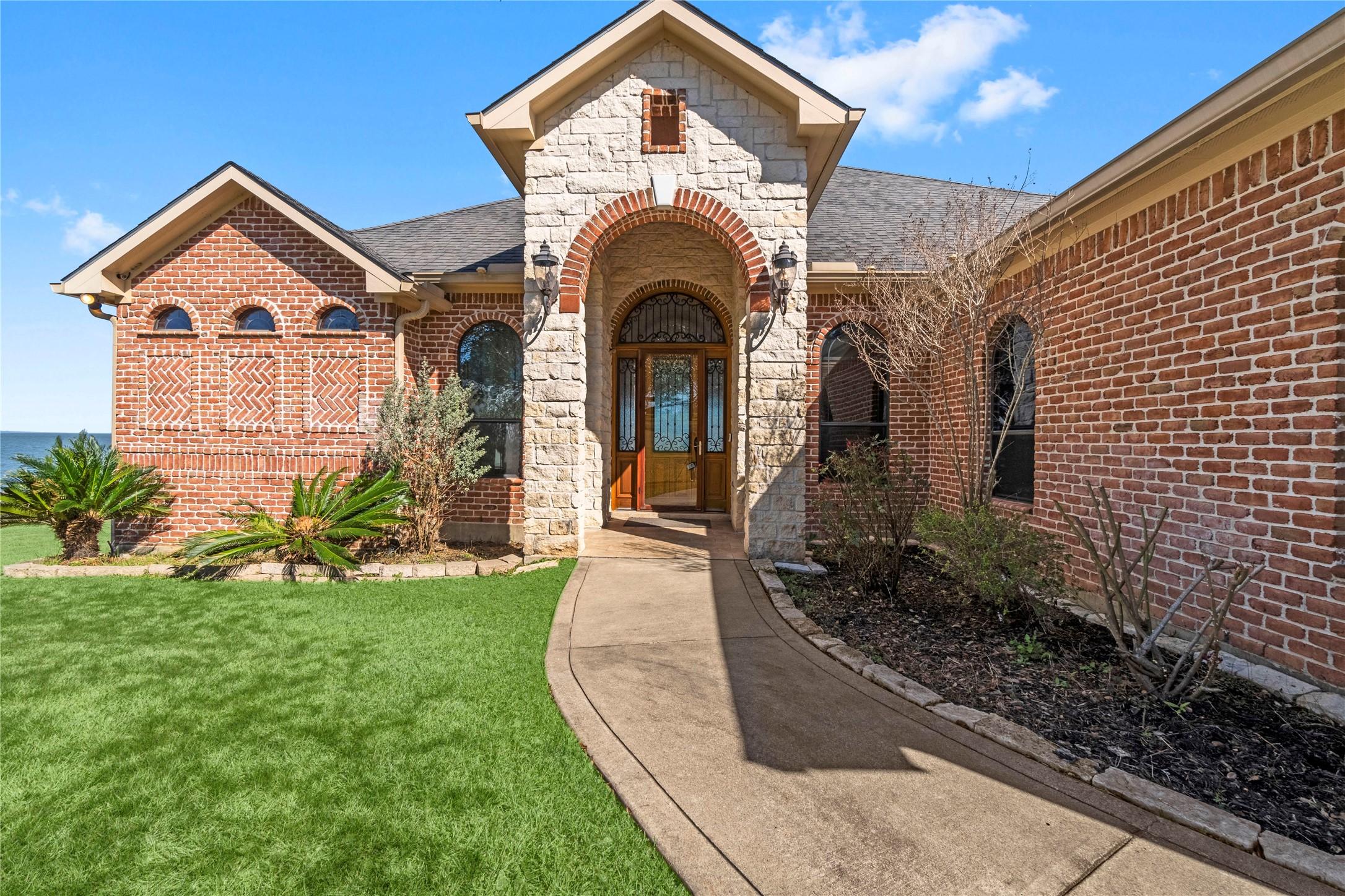 Image 3: stone-accented entrance and arched windows and cus