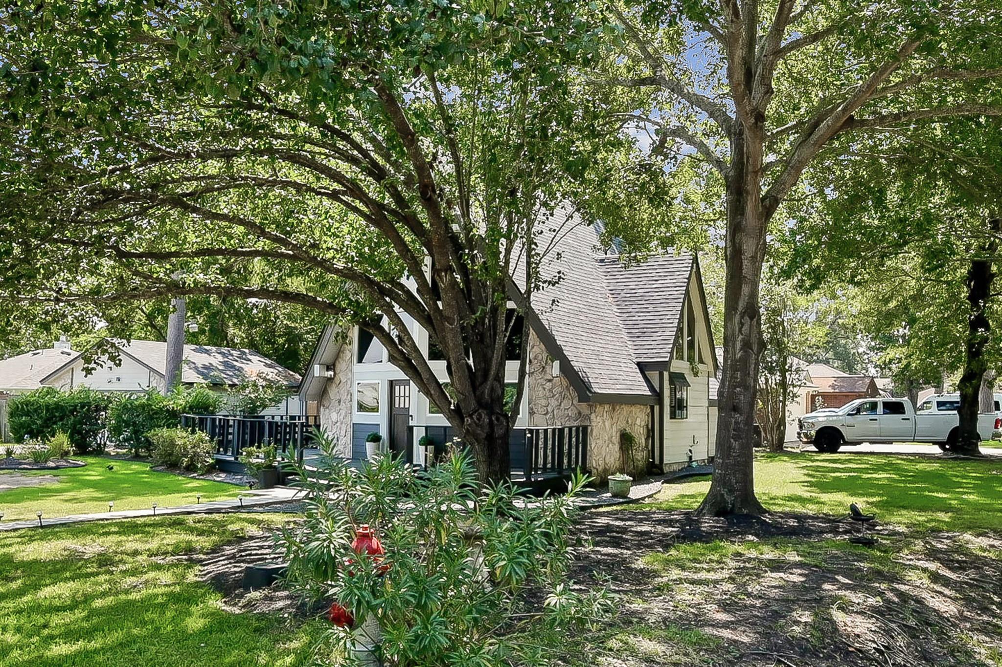 Image 4: Nestled beneath mature shade trees, this unique A-