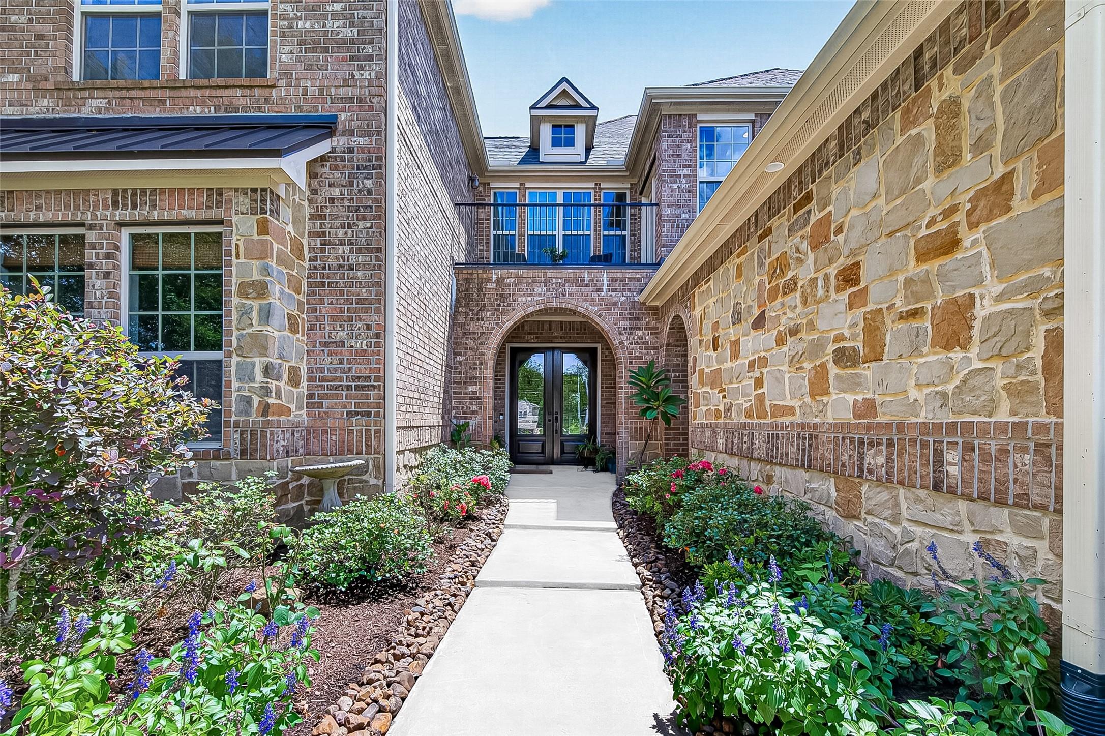 Image 2: Follow the charming front walkway surrounded by lu