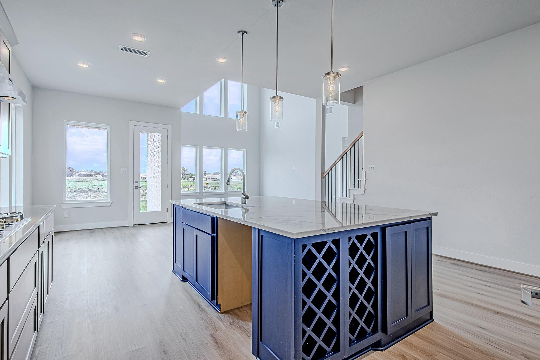 Image 3: A peek around the island reveals a built-in wine r