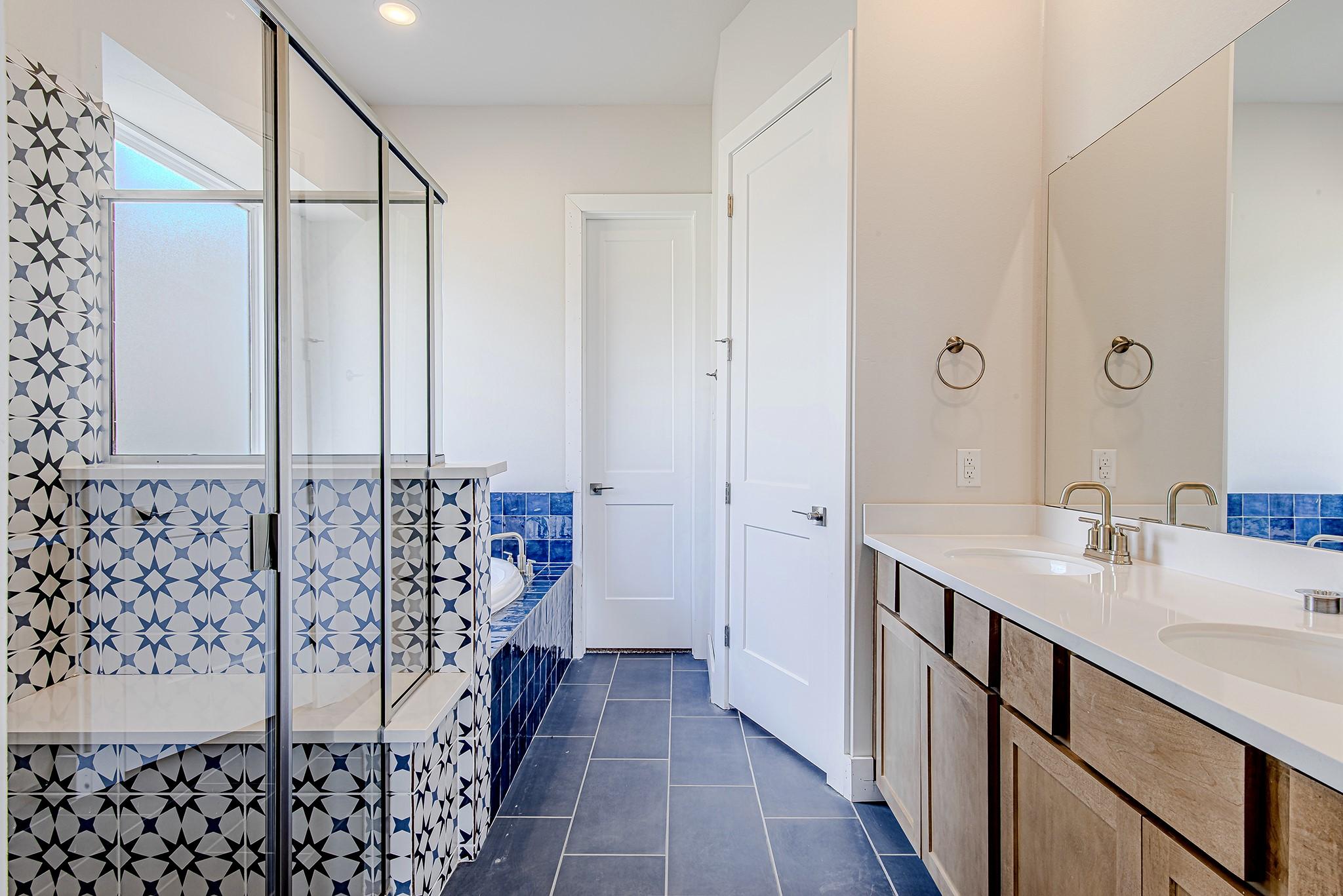 Image 4: The primary bath features dual vanities, designer