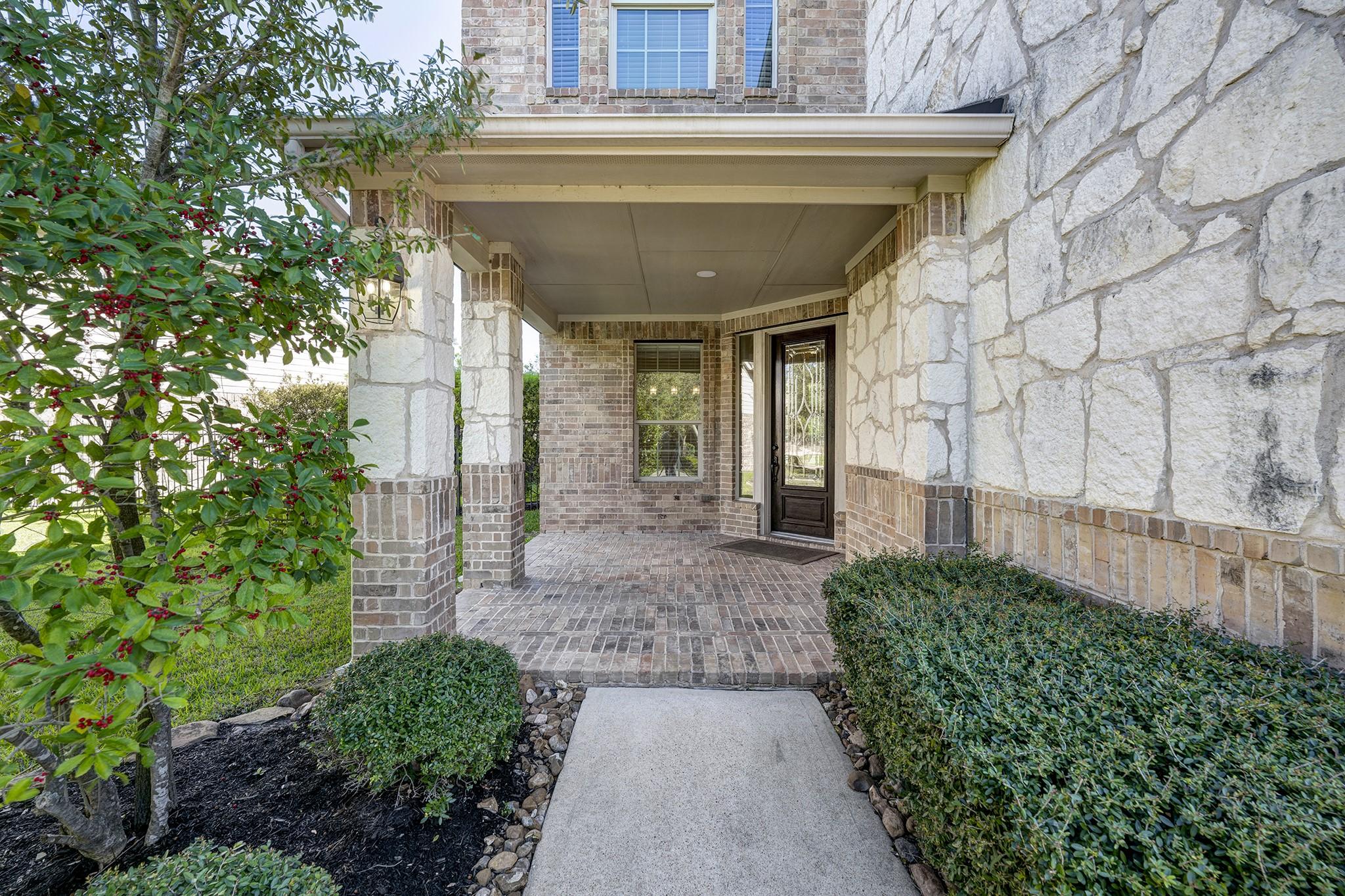 Image 2: You are welcomed by a deep front porch with a bric