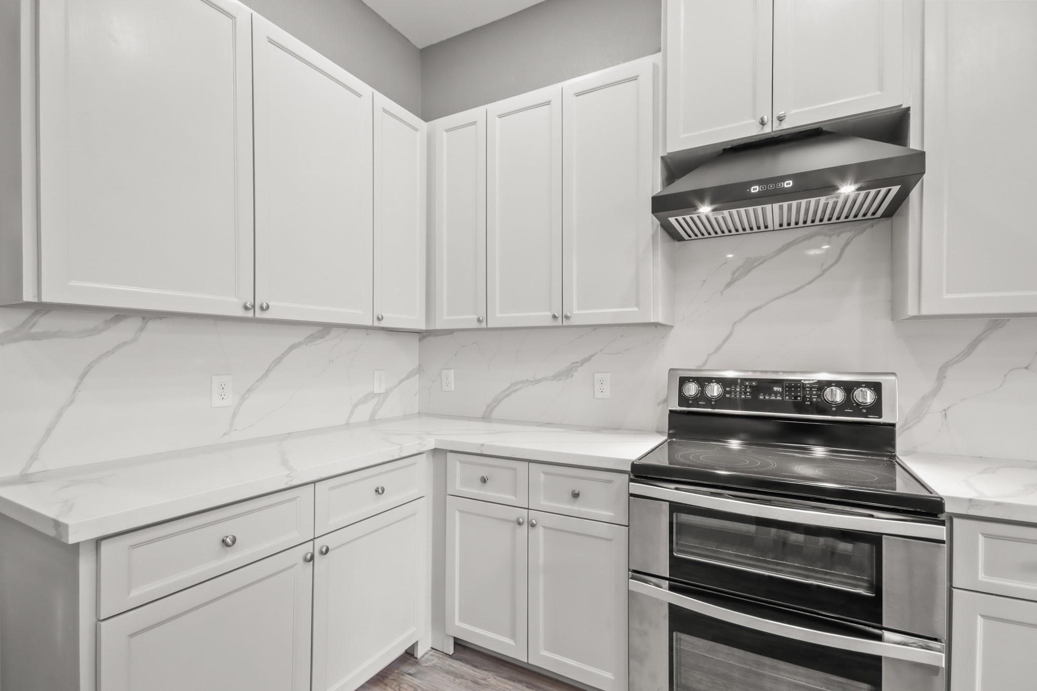 Image 2: Beautiful neutral kitchen with double ovens.