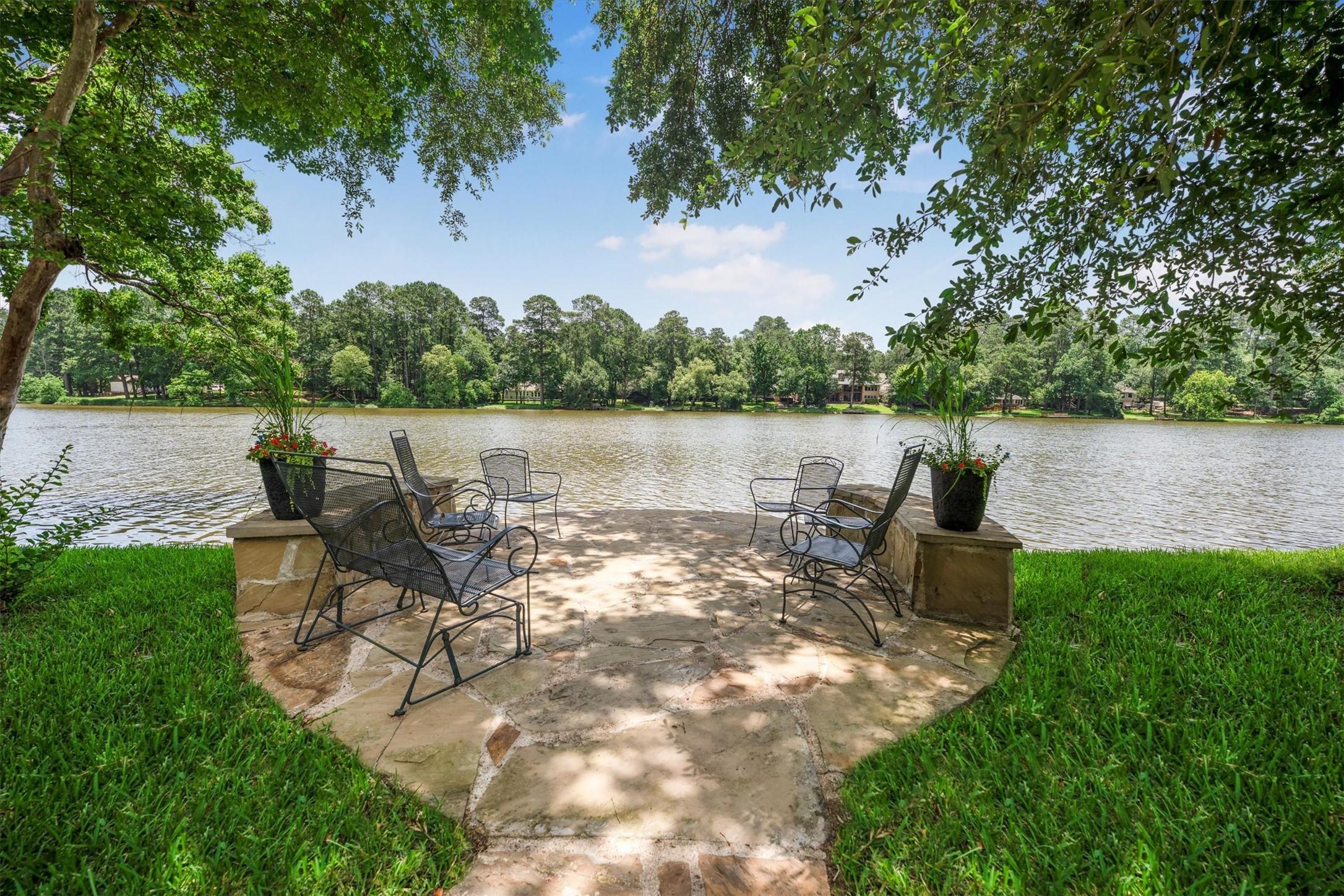 Image 1: Serene stone patio nestled under mature trees with