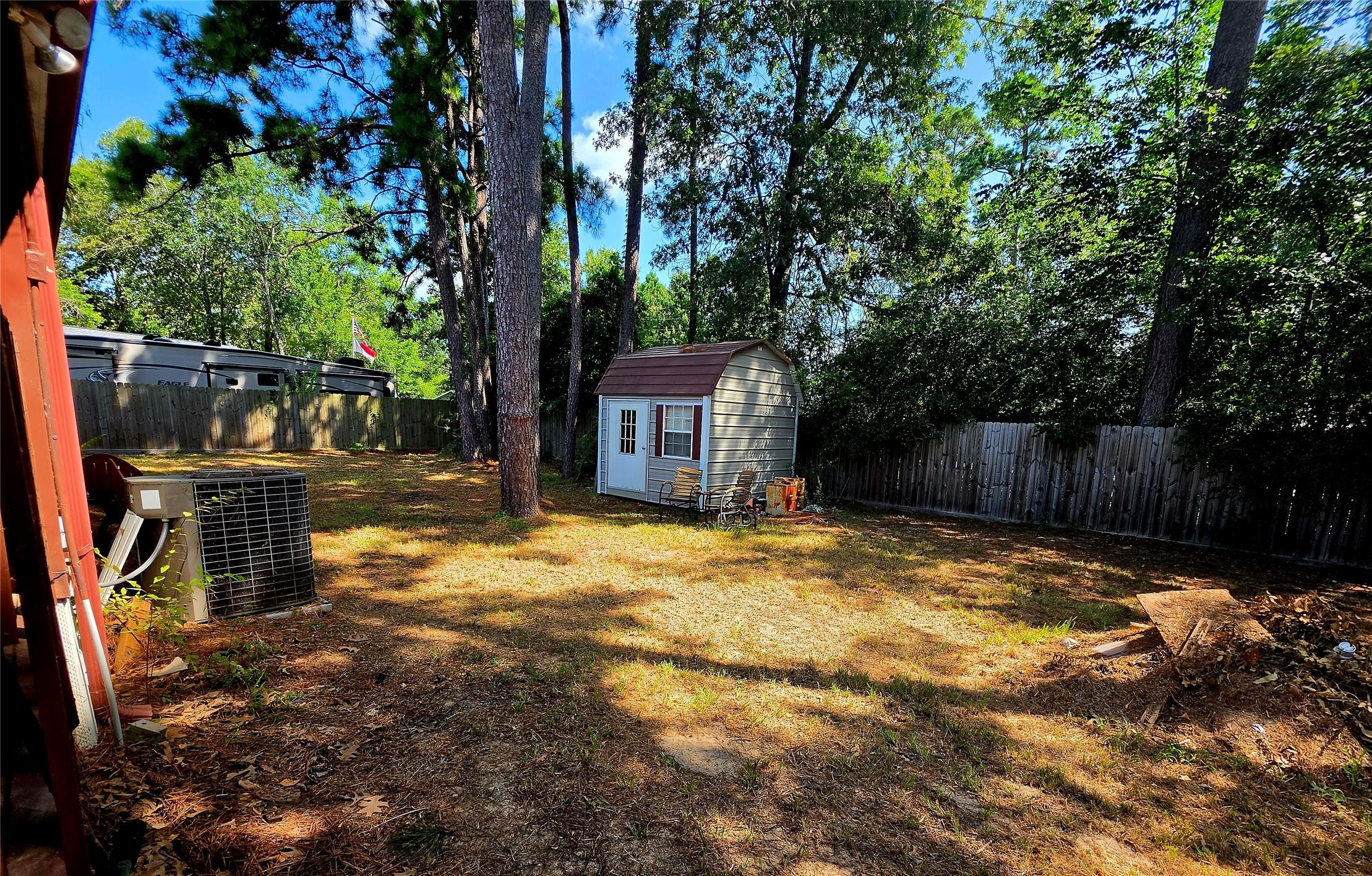 Image 2: Fenced Back Yard with mature trees.