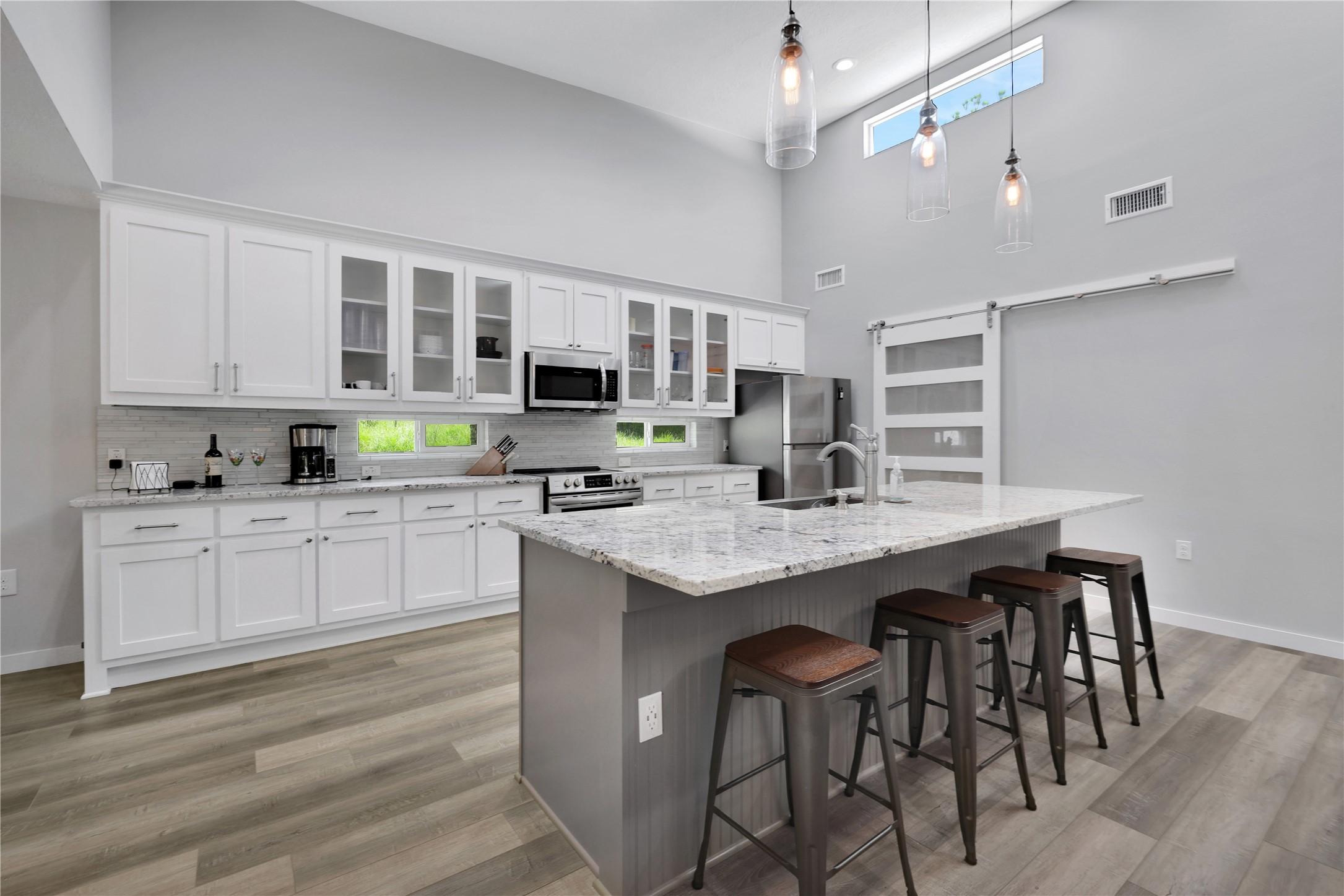 Image 4: The kitchen boasts modern finishes, including slee