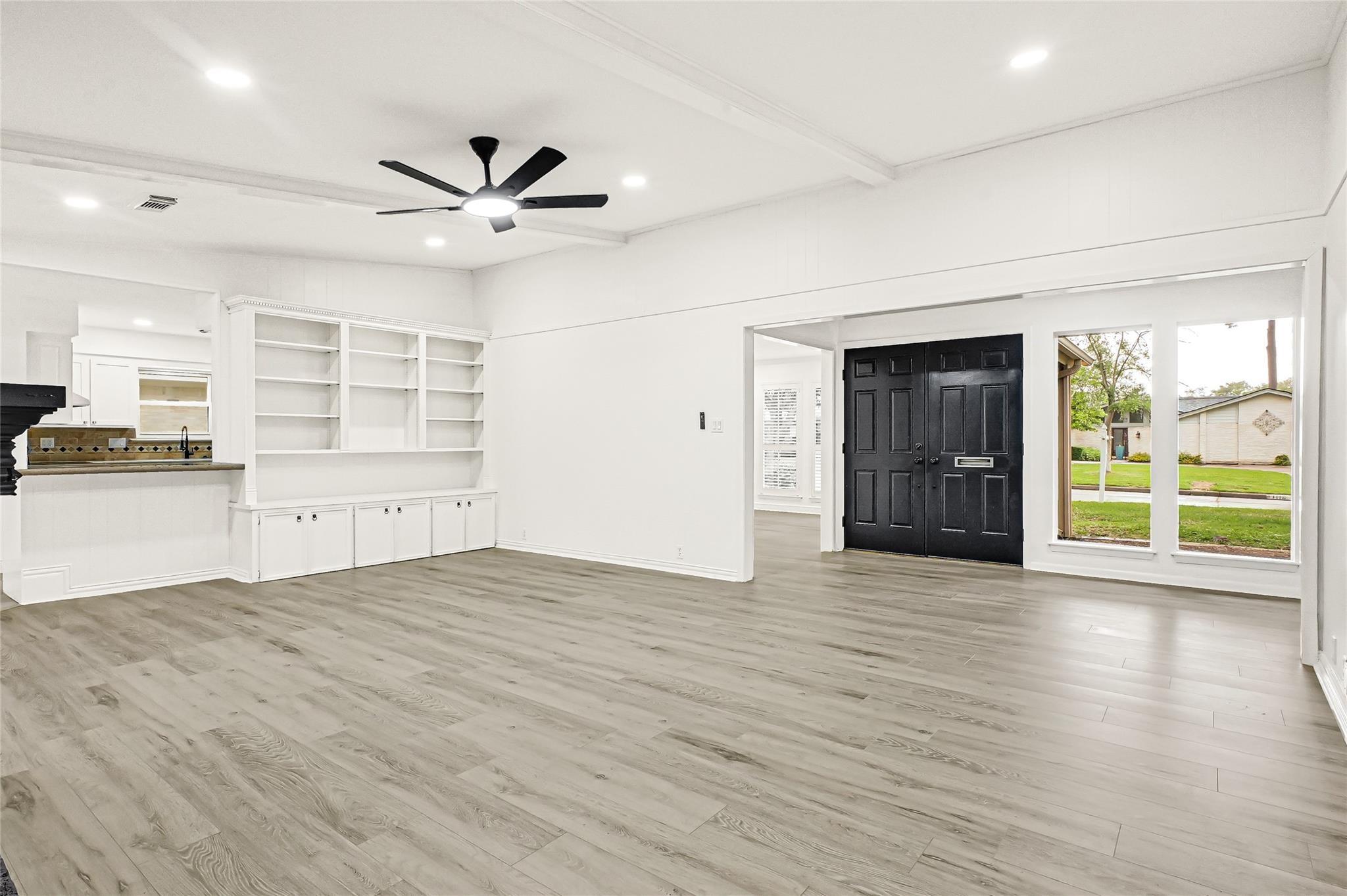 Image 3: This spacious living area features elegant wood fl