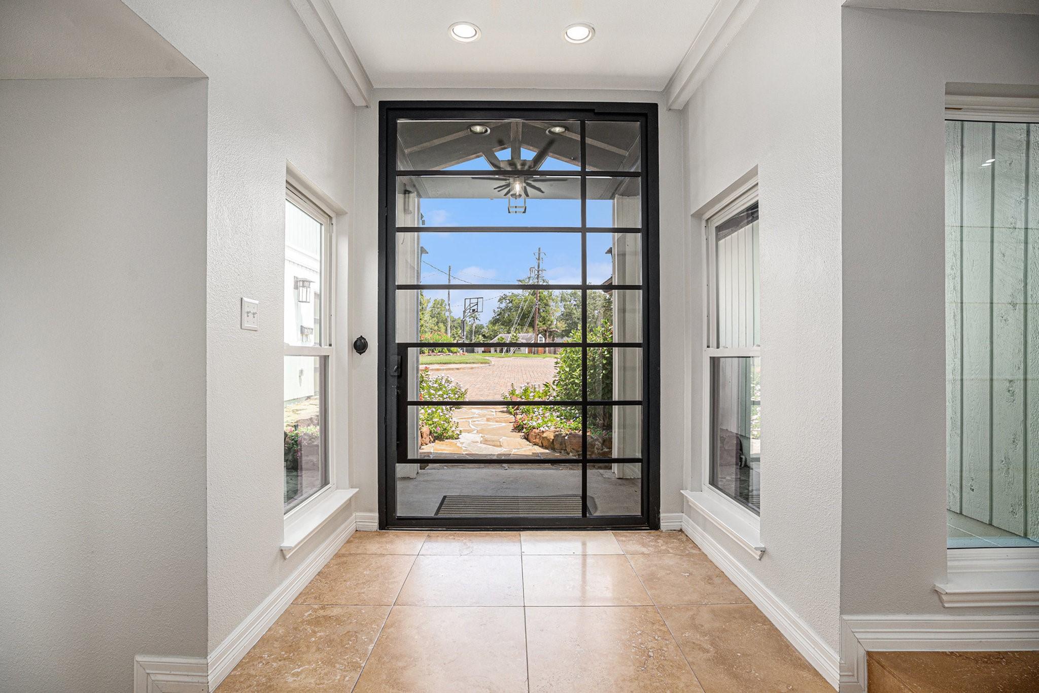 Image 4: Bright entryway featuring a modern glass-panel fro