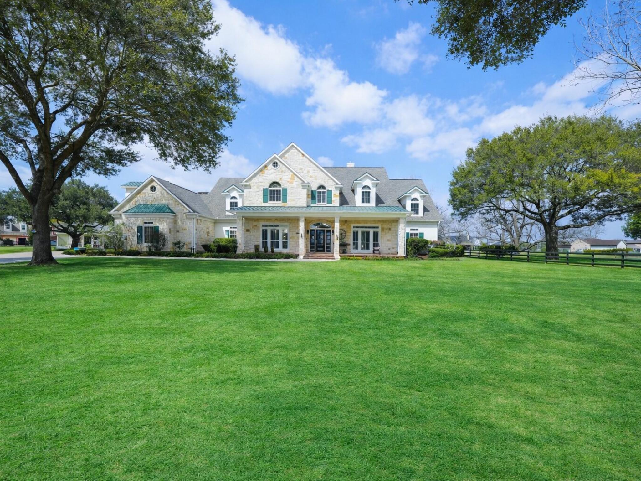 Image 4: Rolling green lawns and stately trees frame the ho