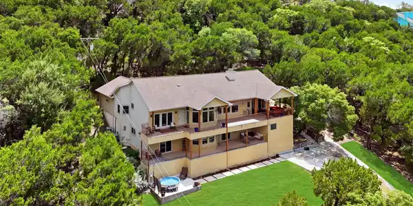 Image 4: Nestled among mature trees on a generous hilltop l