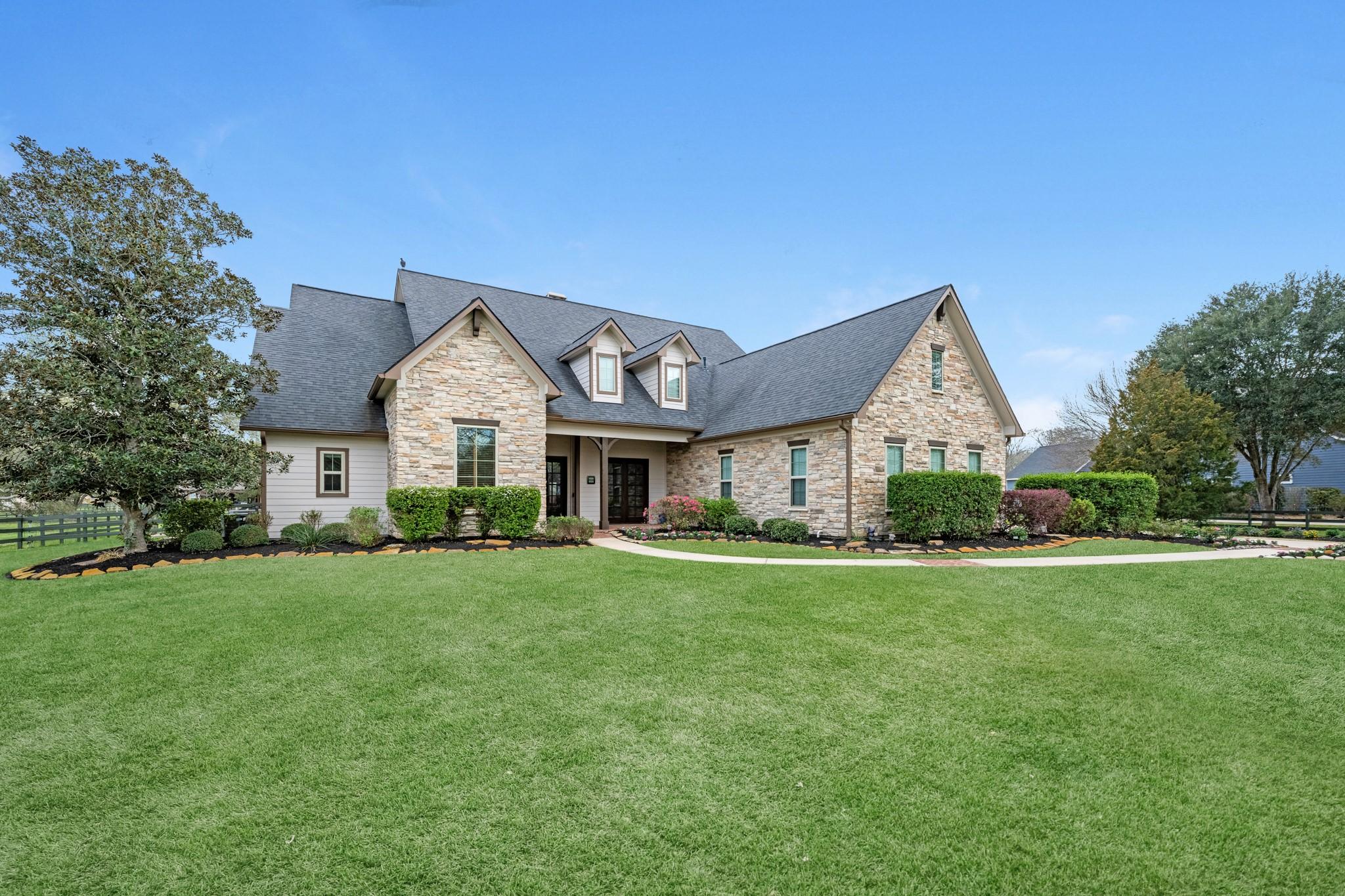 Image 2: Set against wide open green space, this stunning h