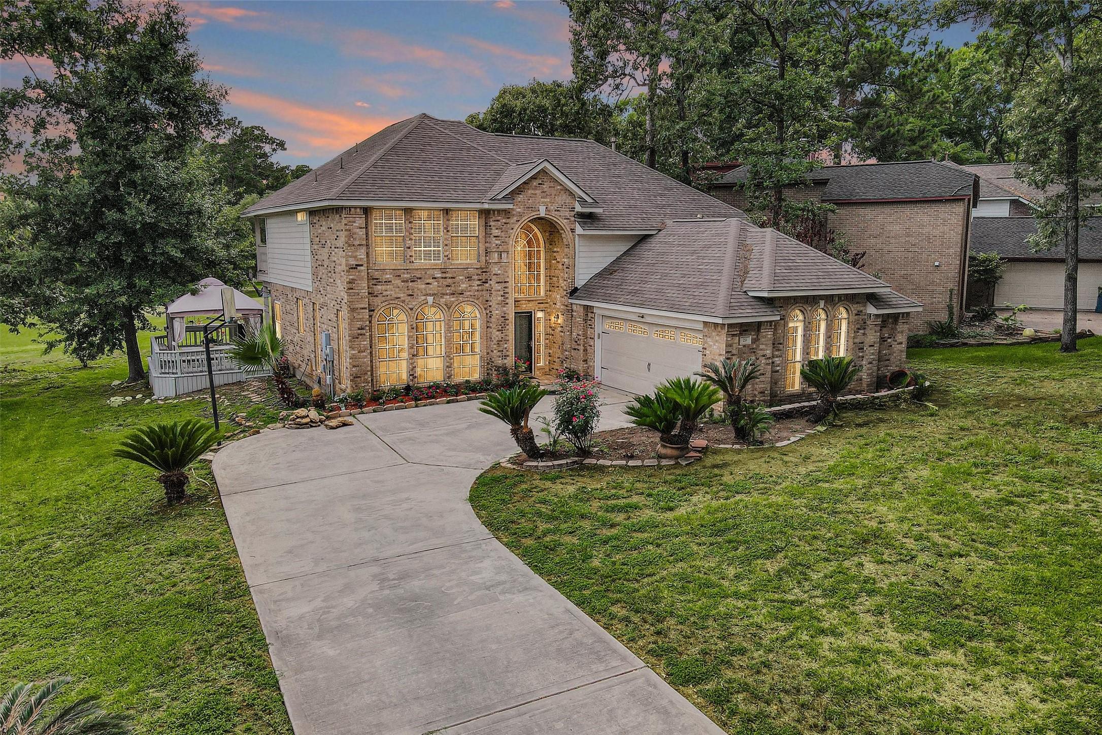 Image 1: This impressive two-story brick home features larg