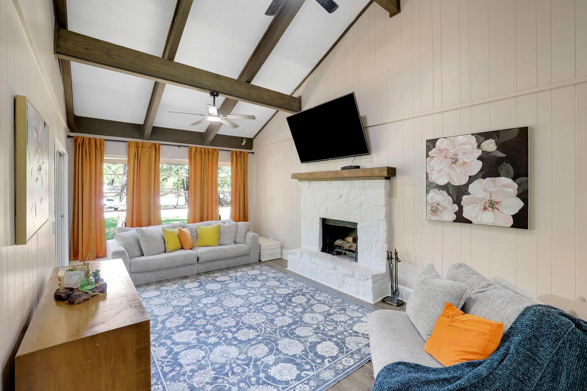 Image 3: The living area has a wood burning fireplace