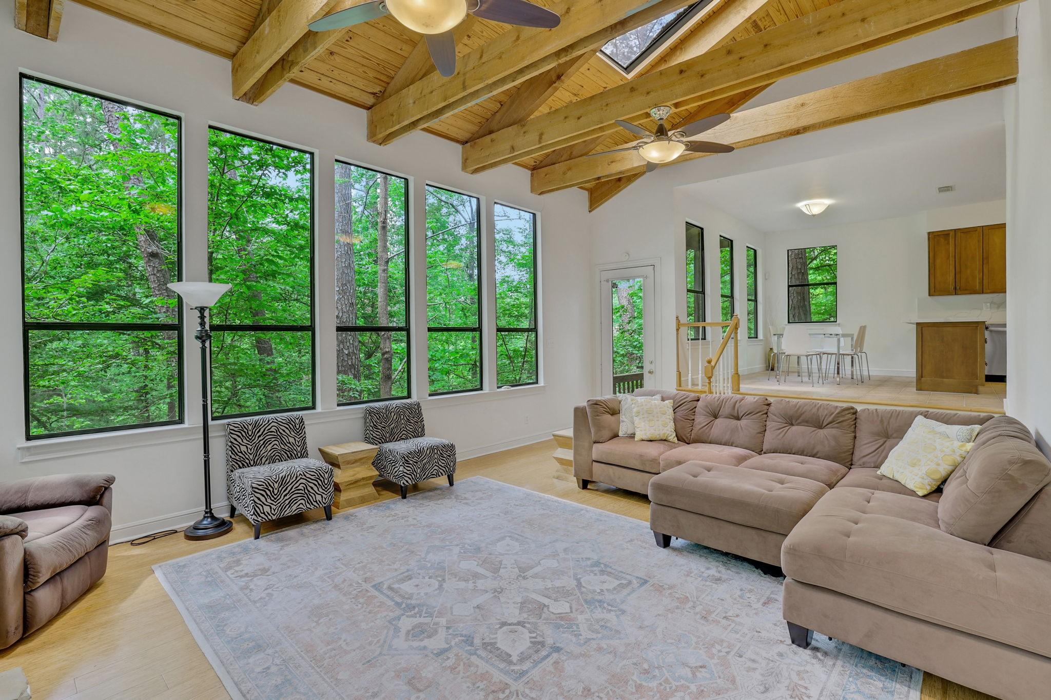 Image 3: The living area has high valued ceilings and wood