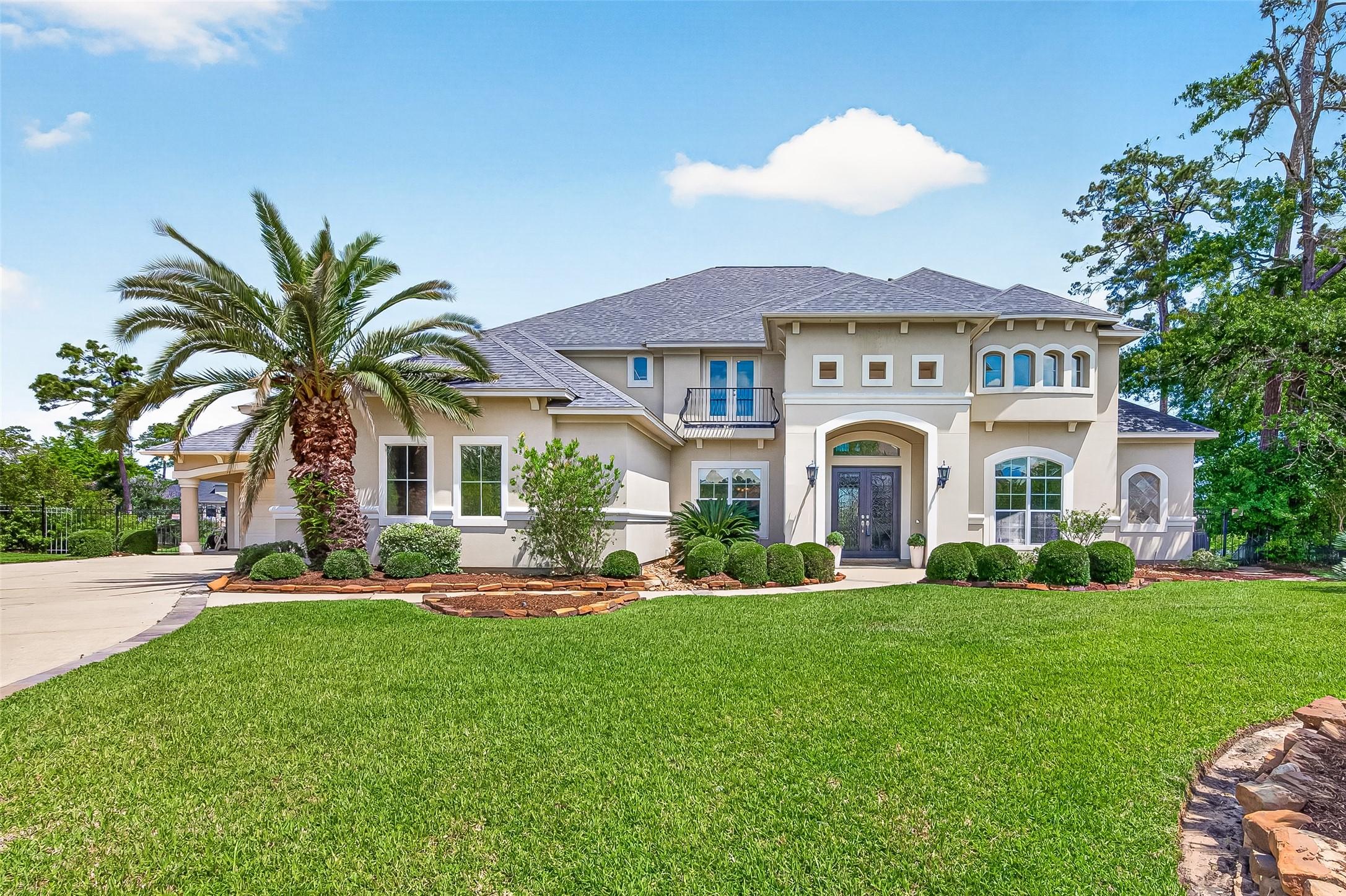 Image 2: This elegant two-story home features a stucco exte