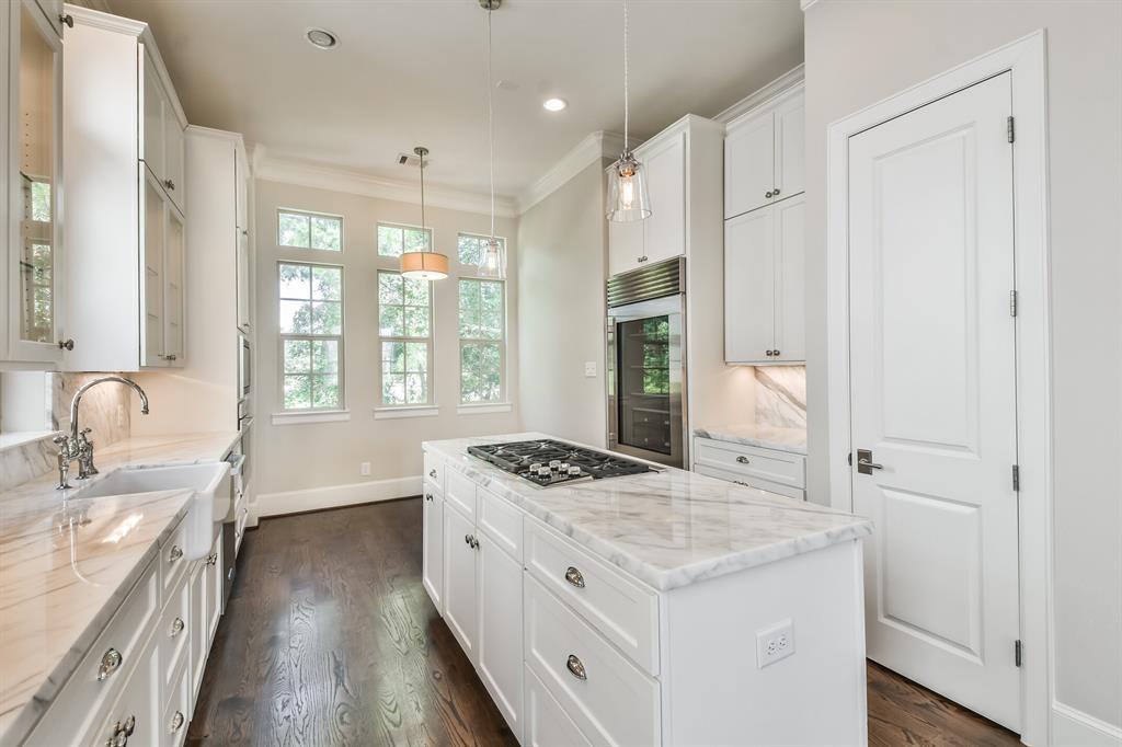 Image 4: This kitchen features elegant white cabinetry, mar