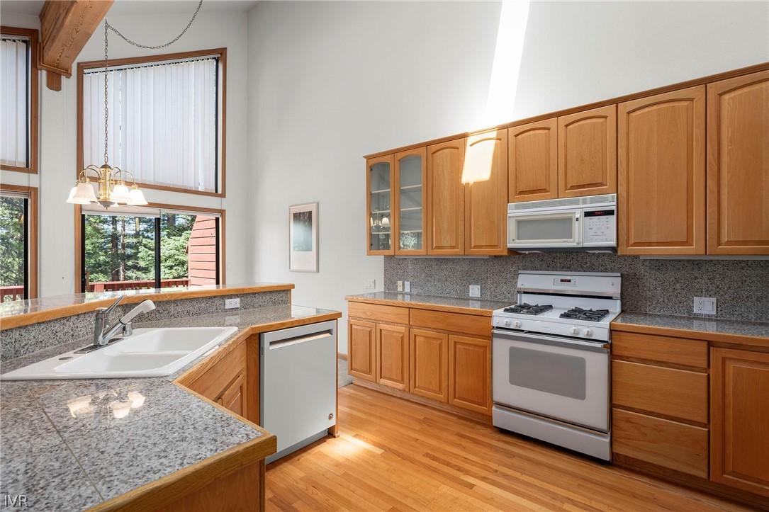 Image 4: Kitchen With Ample Cabinetry and an Elevated Break