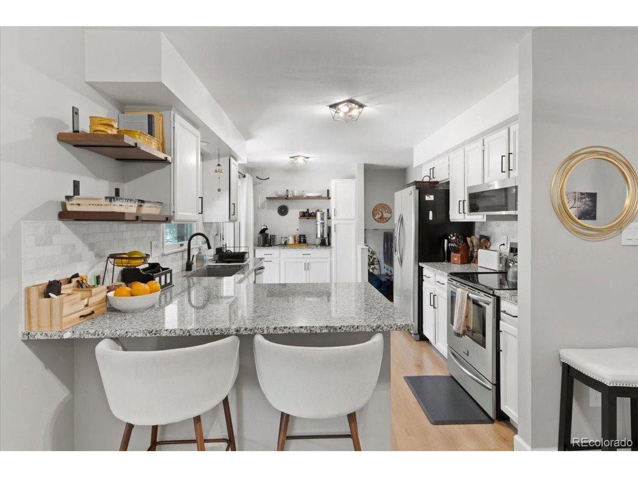 Image 3: Beautifully remodeled kitchen with eat up peninsula, granite counter tops, and stainless steel appliances.