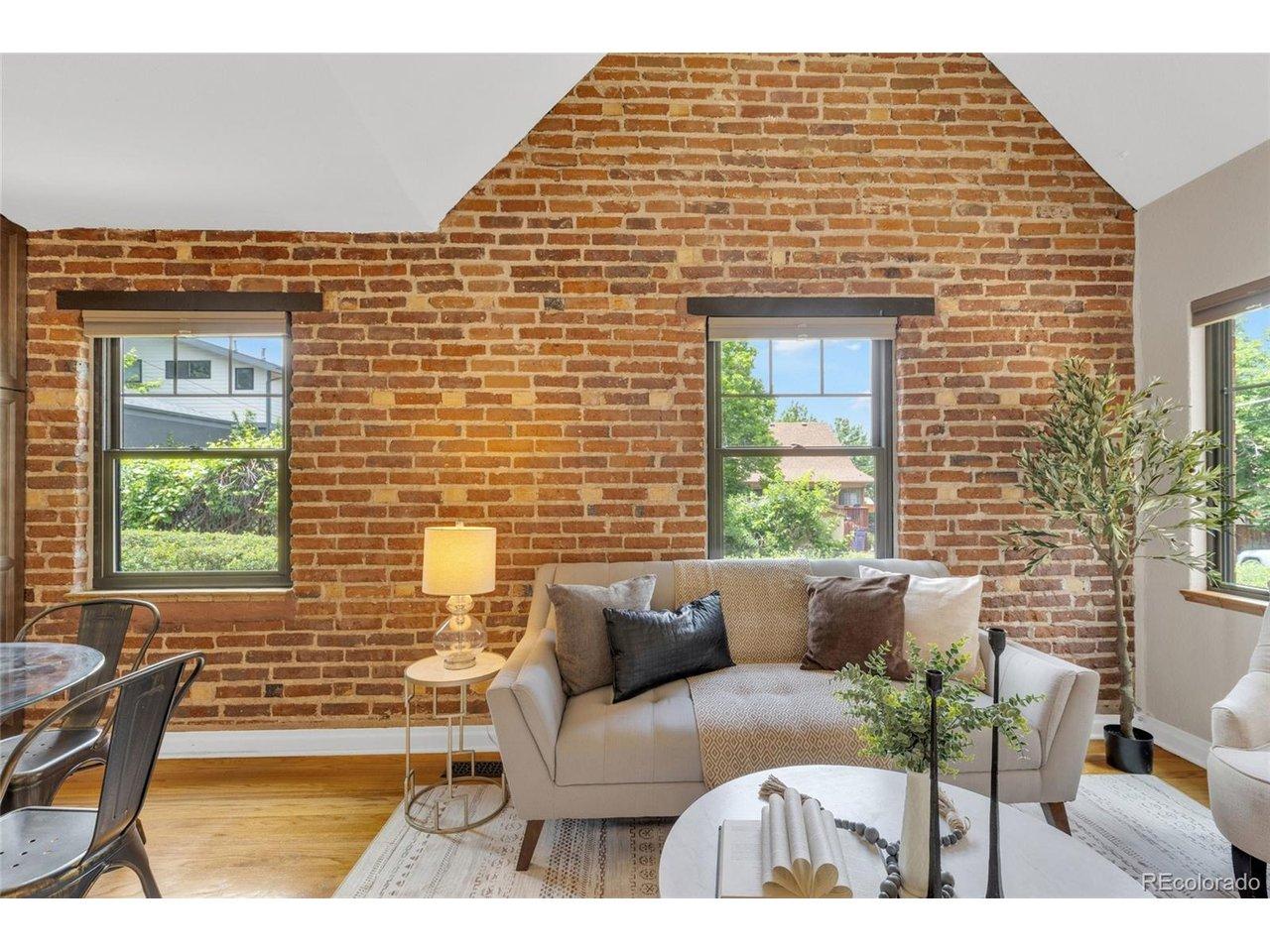 Image 4: vaulted ceiling in living area with exposed brick