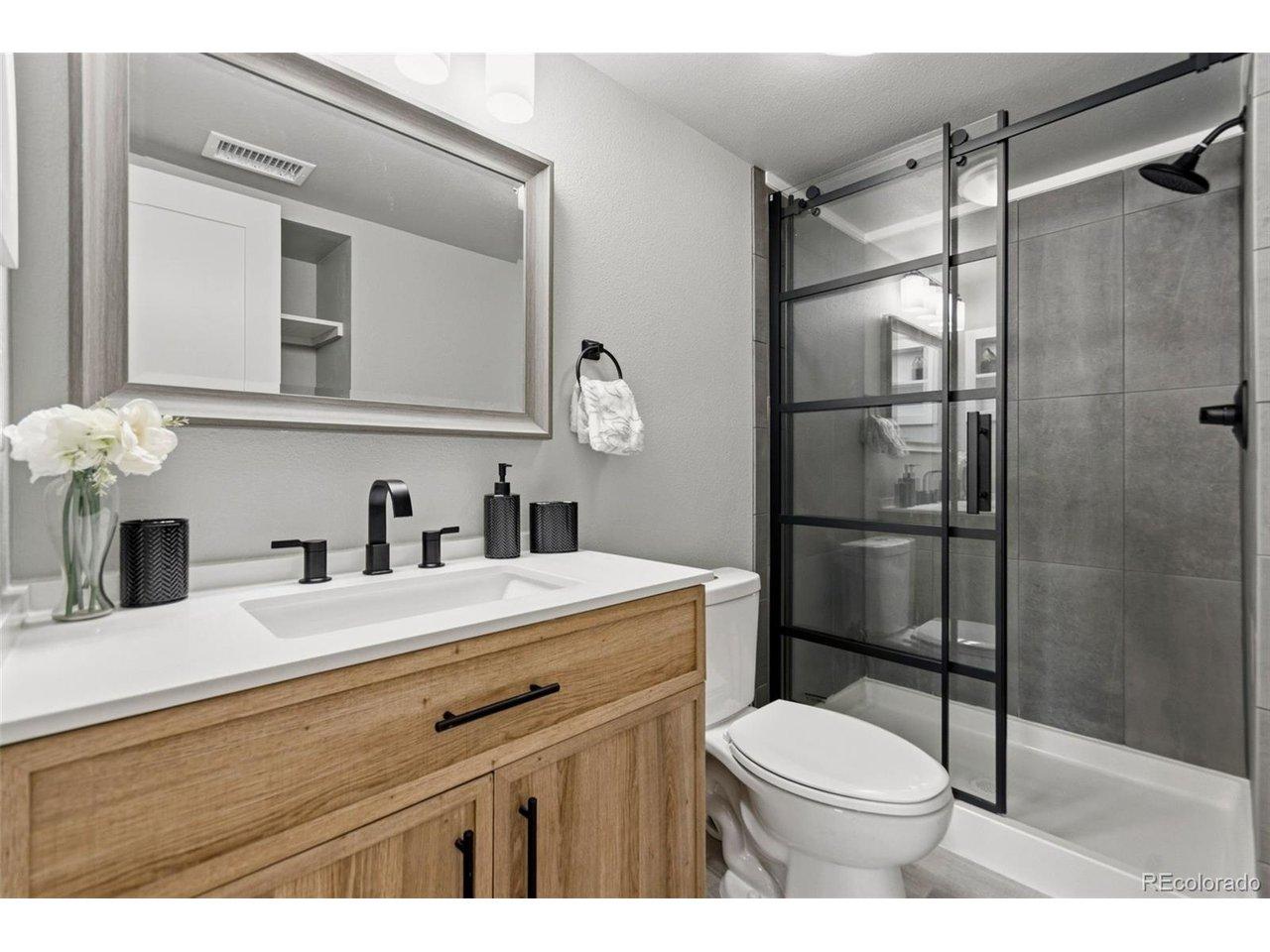 Image 3: Fully updated primary bathroom with tile surround shower, new shower glass door, new shower insert, new vanity, and new flooring! Image 3: Fully updated primary bathroom with tile surround shower, new shower glass door, new shower insert, new vanity, and new flooring!