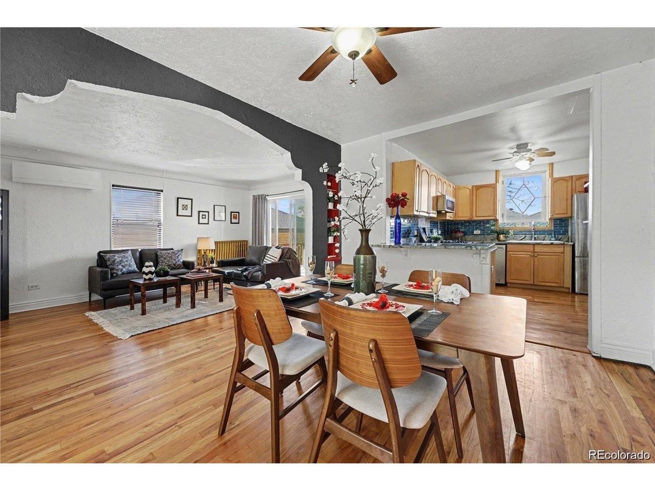Image 1: Bright, open-concept living space with warm hardwood floors and great natural light! Charming architectural details and large windows add to the home's inviting feel!