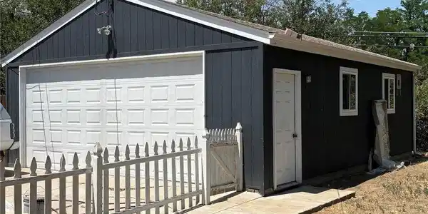 Image 2: Four-car detached oversized garage with rafter storage, side door entry, opener and keypad entry.