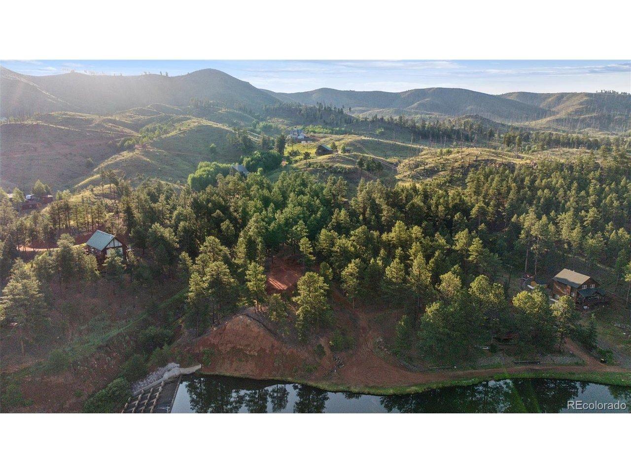 Image 4: Aerial overview of property's location with a water and mountain view and a heavilywooded area.